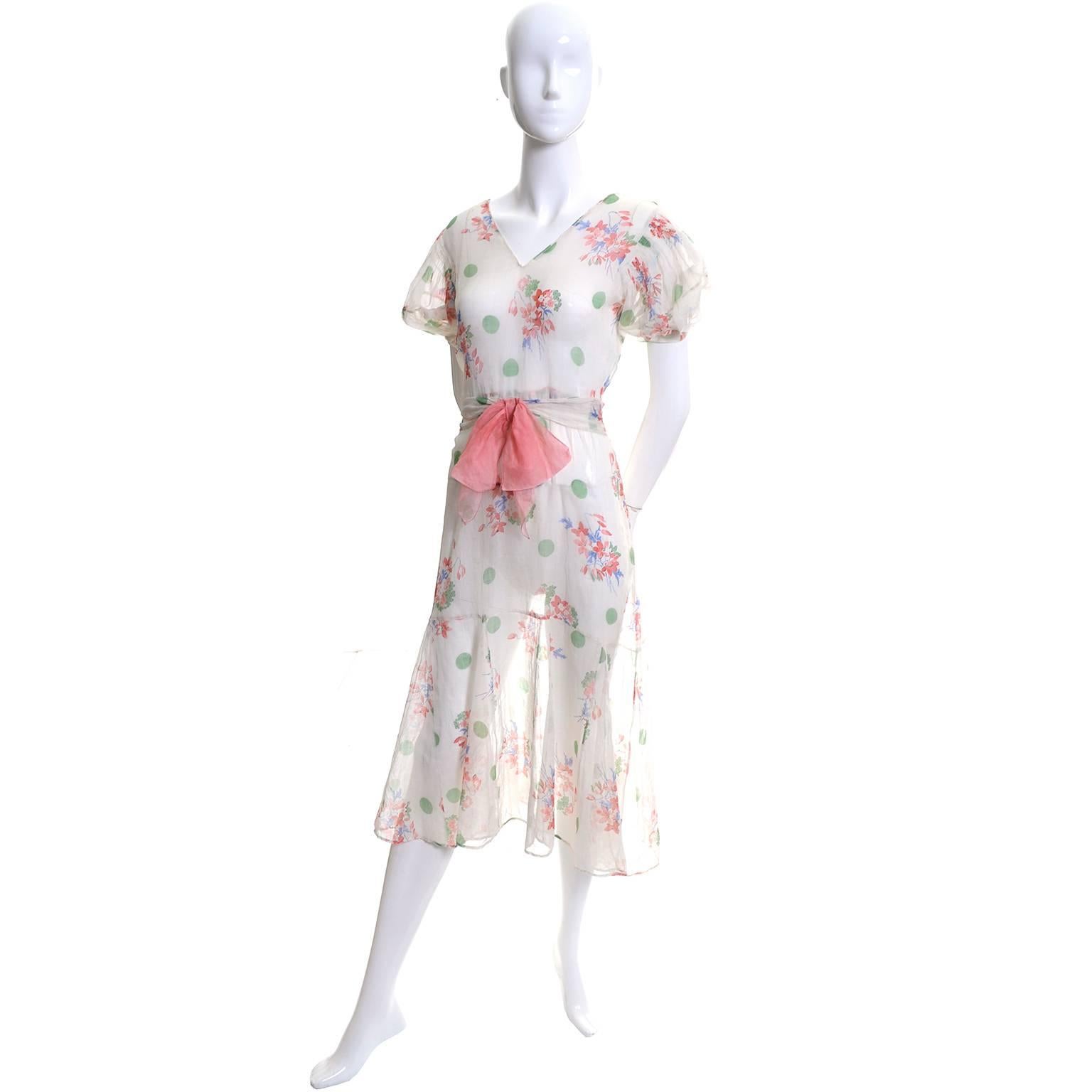 I adore this pretty organdy vintage 1930's floral dress.  The floral print also has green polka dots and the sleeves have smock pleating.  This dress is cut on the bias and has an attached sash that has a pink bow that connects to the dress with a