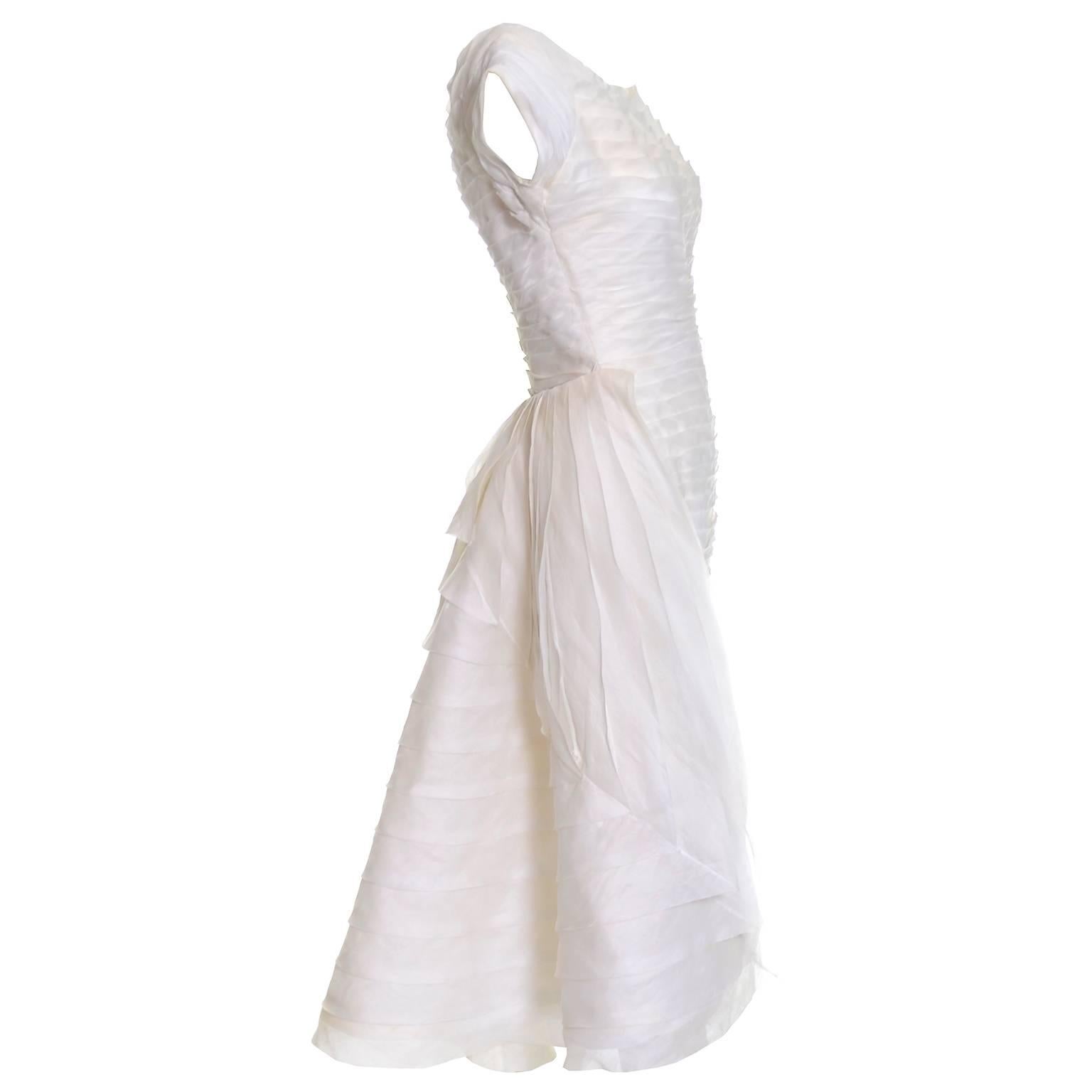 This is an absolutely outstanding vintage dress from William Cahill of Beverly Hills.  I have sold several Cahill vintage wedding dresses over the years and this one is one of my favorites!  The simple ivory organza wiggle dress is pleated and has a
