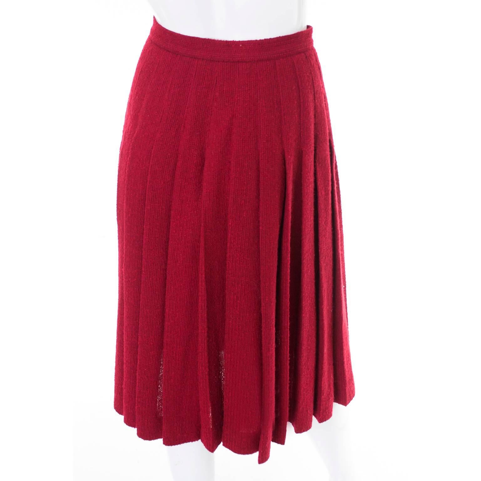 This is a fabulous vintage skirt designed by Yves Saint Laurent in the 1990s. The burgundy wool boucle skirt is beautifully pleated and has nice gold buttons on the front at the side. The back of the skirt is fully pleated and the front shows