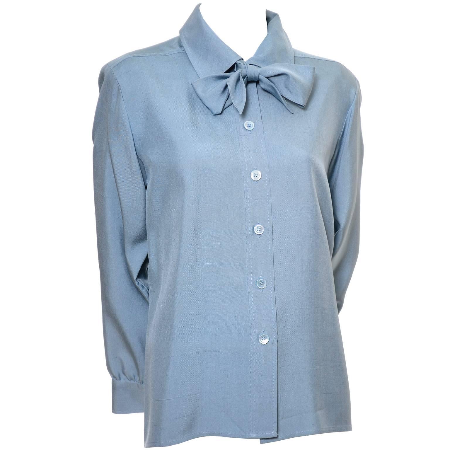 This pretty vintage blue silk blouse was designed by Yves Saint Laurent in the late 1970's. This raw silk button front blouse has a a tie at the neck that can be tied into a knot or a bow.  The blouse is labeled a French size 38 and was made in