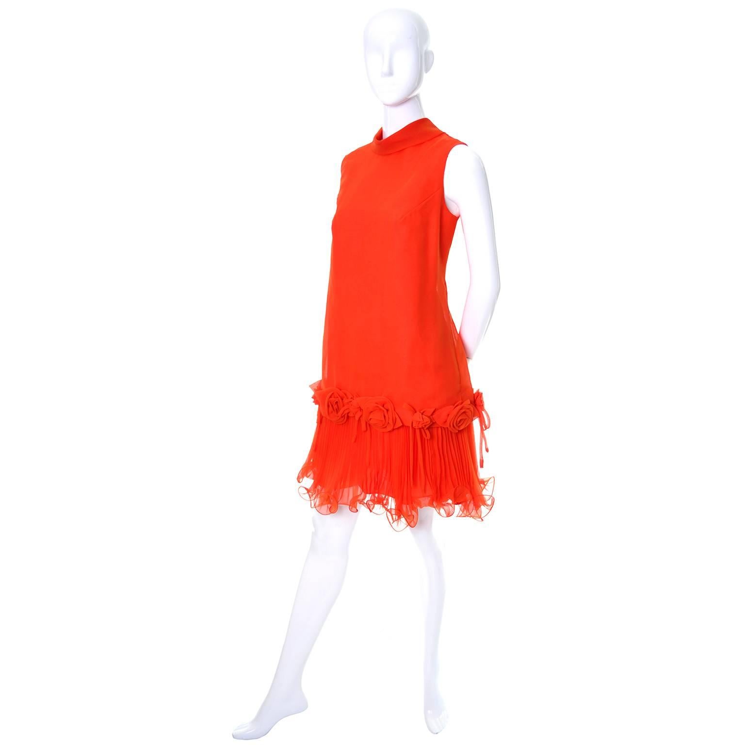 This vintage but new Jack Bryan sleeveless dress was designed by Dupuis and still has its original tag attached.  The dress is tomato orange/red chiffon over a satin underdress lining.  There is a back zipper and a great sash that ties at the neck