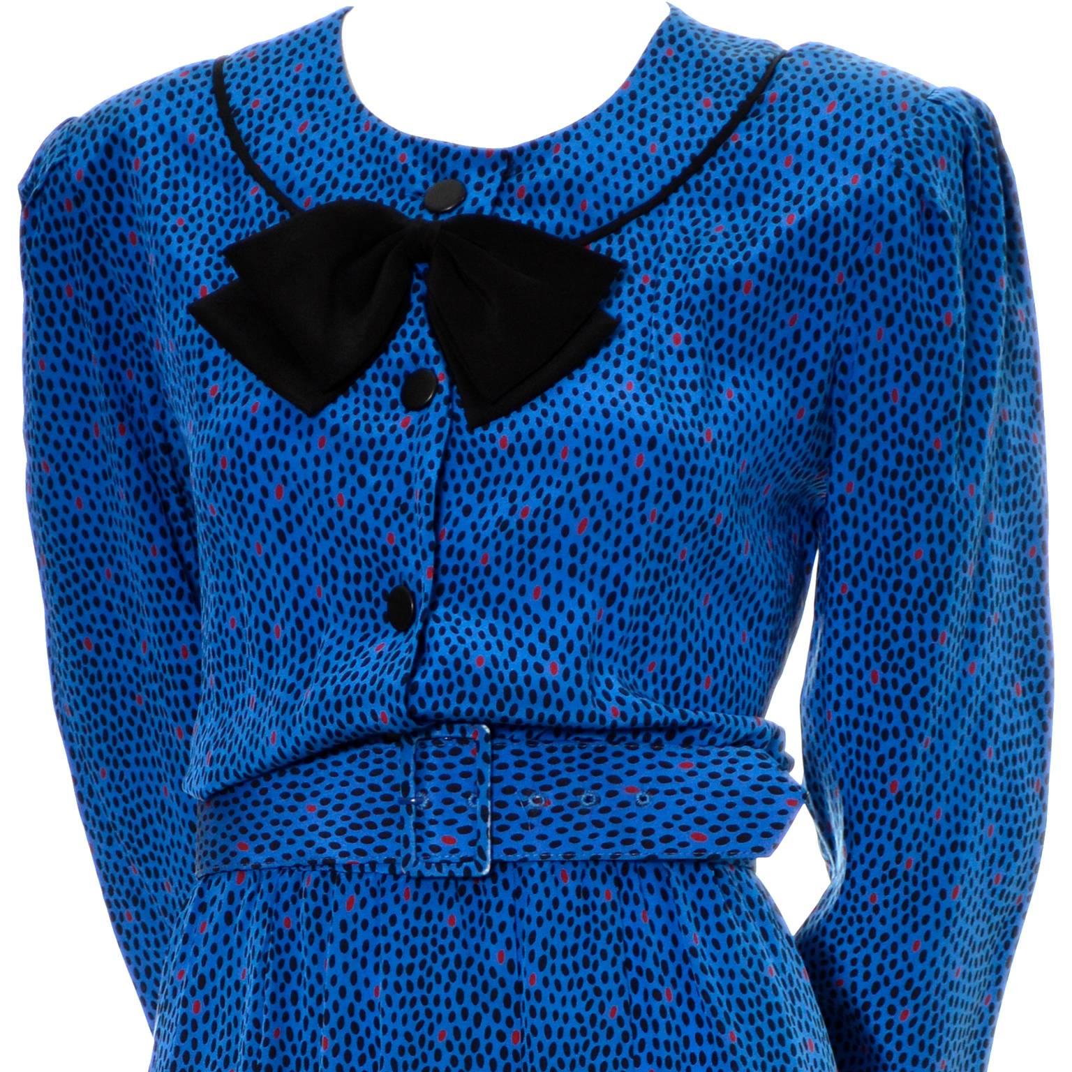 I love Albert Nipon dresses from the 1970's and early 1980's and this one is one of my favorites! This pretty blue silk vintage dress has scattered black and red abstract dots and its original belt.  The dress has a black silk bow at the collar,