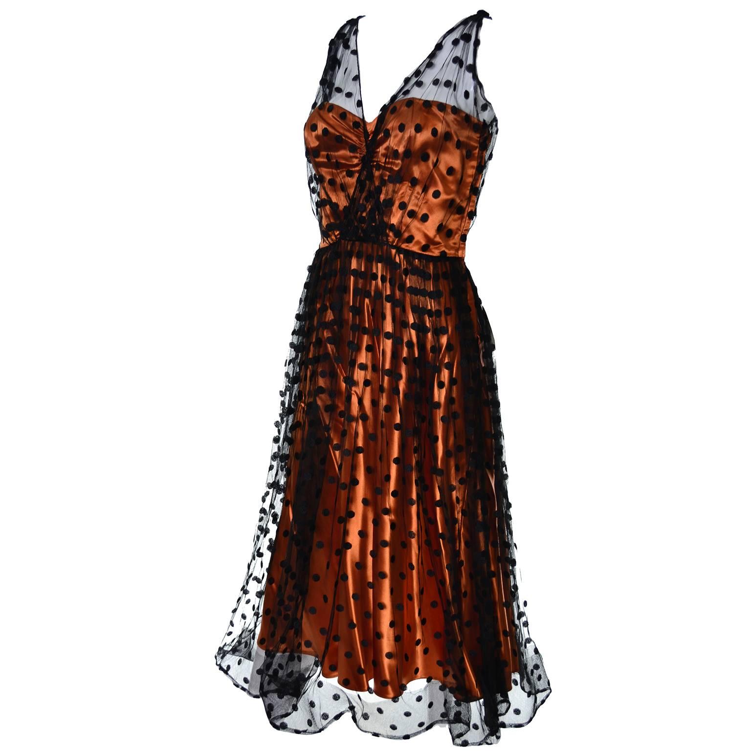 This vintage dress was designed by Ceil Chapman in the 1950's. The strapless dress is orange satin with a black polka dot tulle overlay.  The dress has a side metal zipper. The dress has been shortened and there are tears to the tulle, as shown in