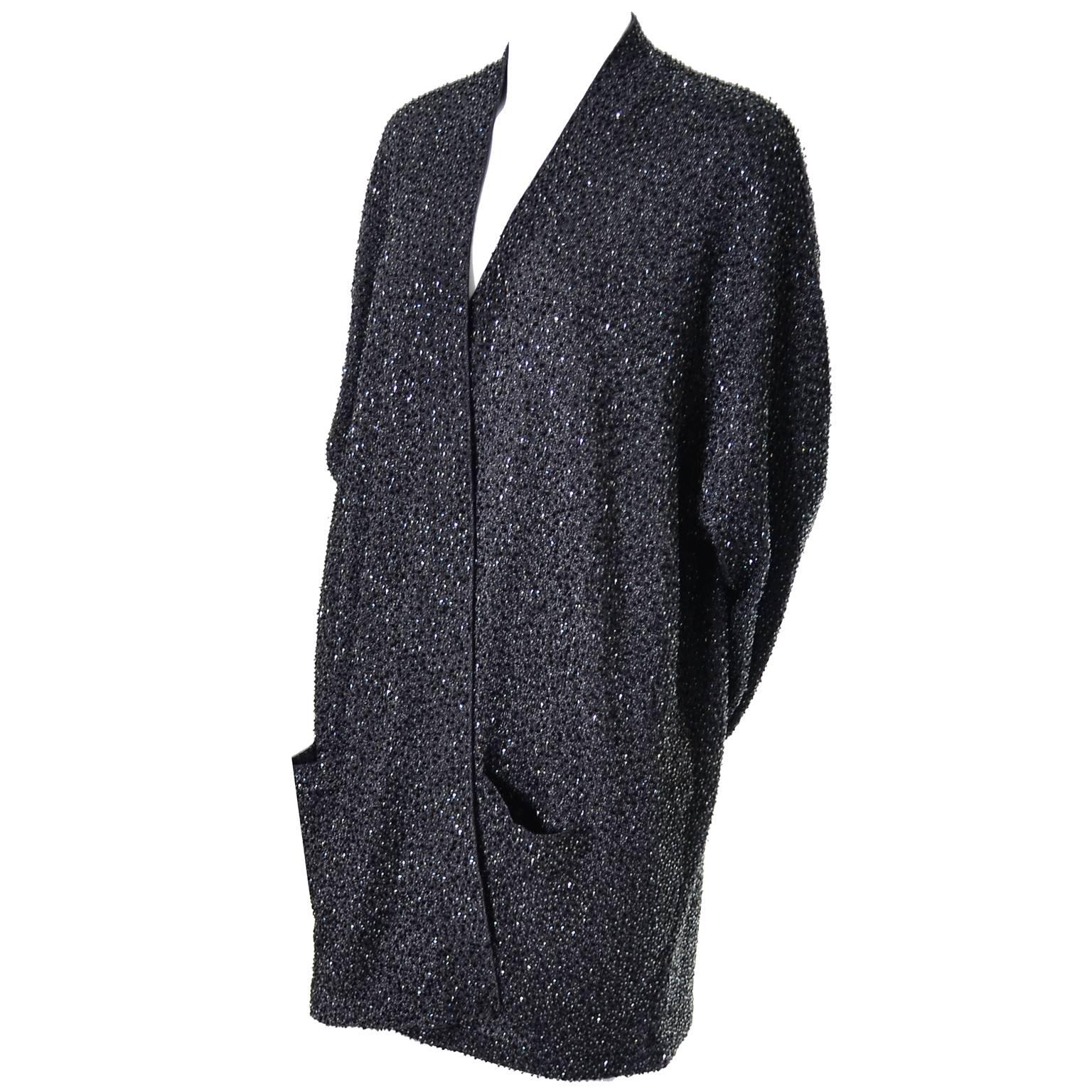 This is an absolutely exquisite vintage evening cardigan from Donna Karan. This is perfect to wear over a little black dress or with a pair of evening pants. This metallic wool/rayon blend open front jacket has front pockets and is covered in tiny