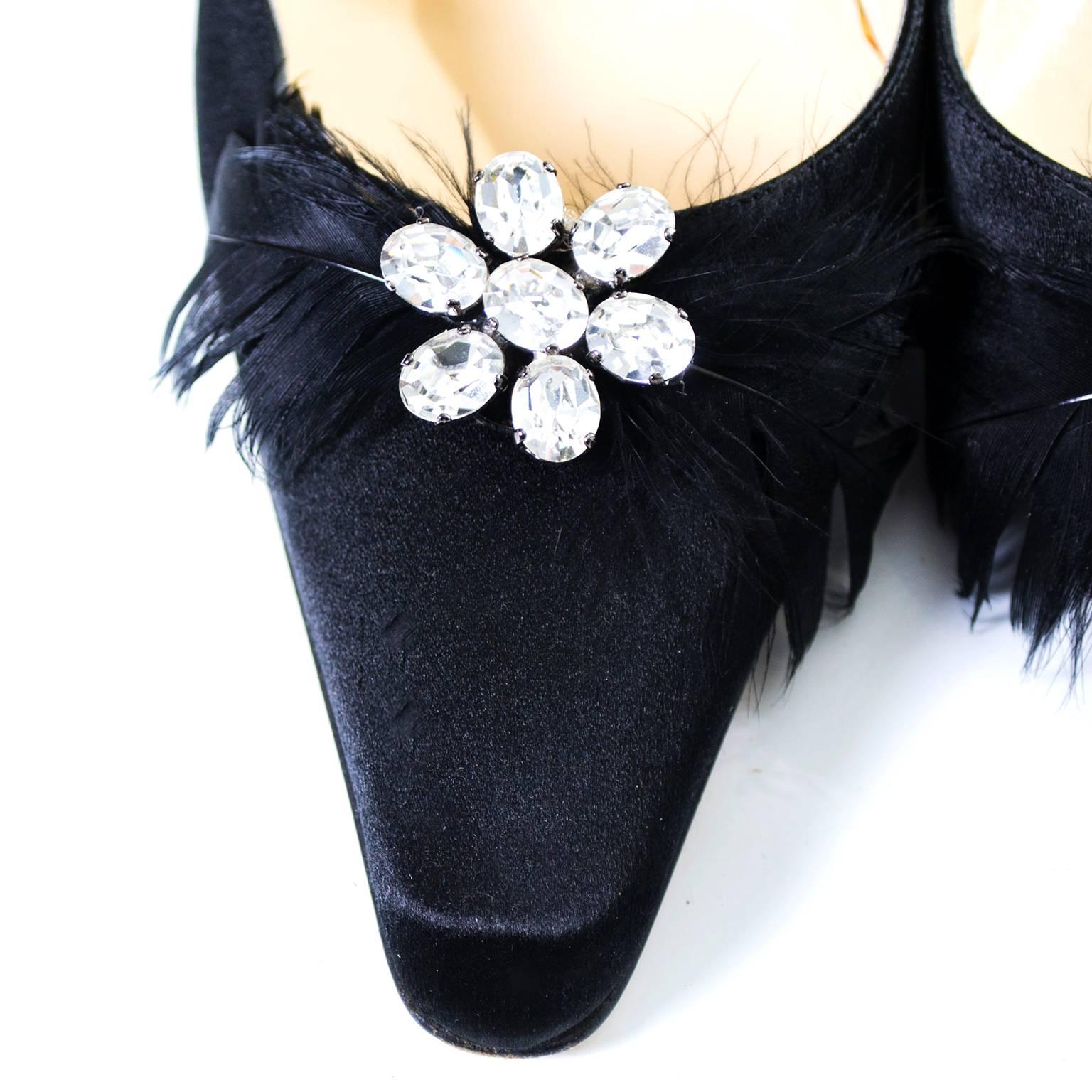 These black satin Jimmy Choo shoes are perfect for the holidays! These designer heels have pretty black feathers and rhinestones and are labeled a size 37.  The shoes are in excellent condition with only minor sole scuffs. The heels are 4.25