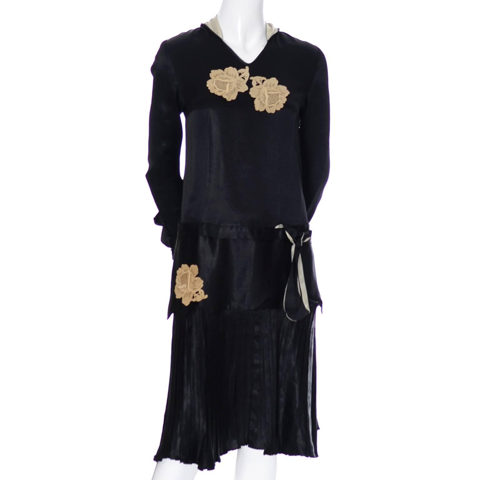 This lovely vintage black silk 1920's dress has a pretty collar that has panels that drape down the back, a pleated drop waist skirt and rose lace applique.  The ruffled cuffs are so beautiful and the cuffs, collar and panels are lined in ivory