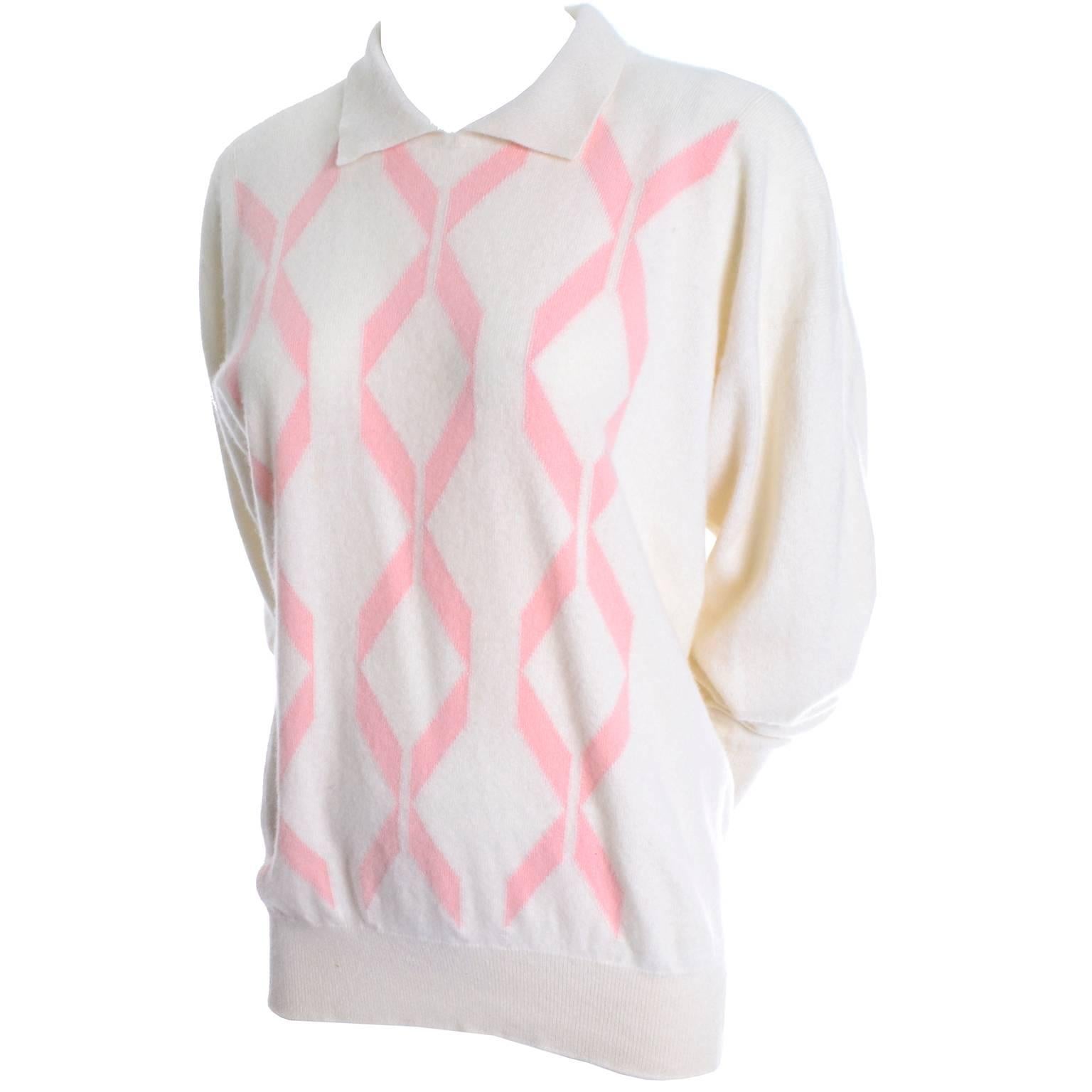 This beautiful vintage cashmere sweater was made in Scotland by Pringle and it is in excellent condition.  The winter white cashmere has a pink ribbon design and the cashmere is so luxurious and soft. This sweater has a collar and long sleeves, and