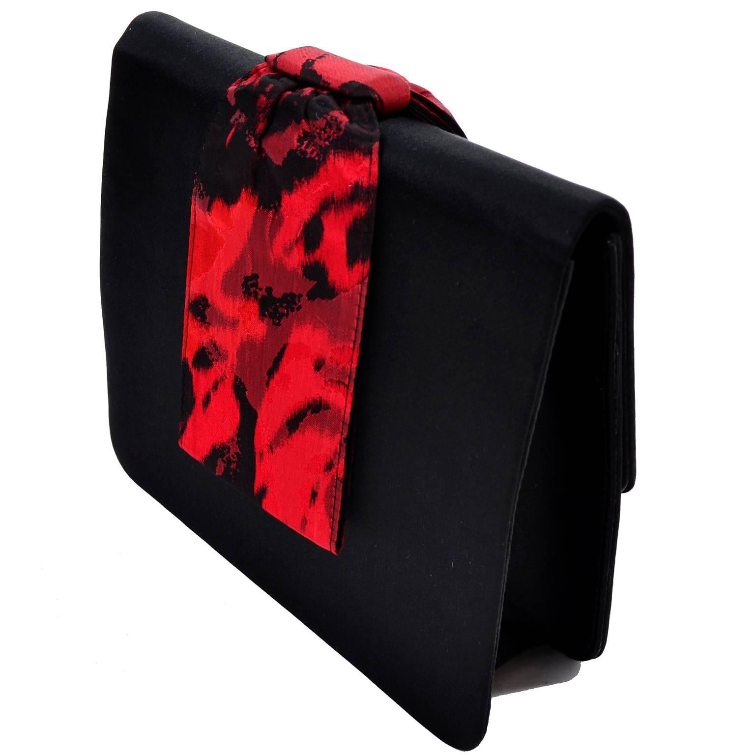 This beautiful signature red Paloma Picasso vintage accessory set has 3 different pieces.  The set includes a black satin clutch handbag with a red and black abstract patterned wrist strap, a black and red satin wrap or scarf, and a pair of fabulous