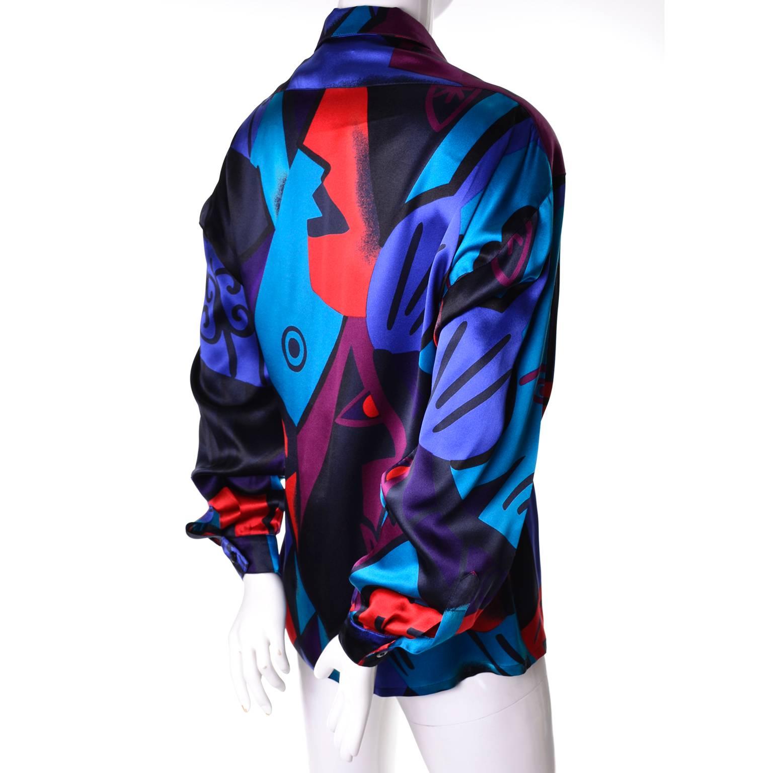 This beautiful 100% silk vintage blouse was designed for Escada by Margaretha Ley. The pattern is made up of abstract swirls and geometric shapes in black, red, green and blue.  Labeled a size 38 and made in West Germany, this top has shoulder pads