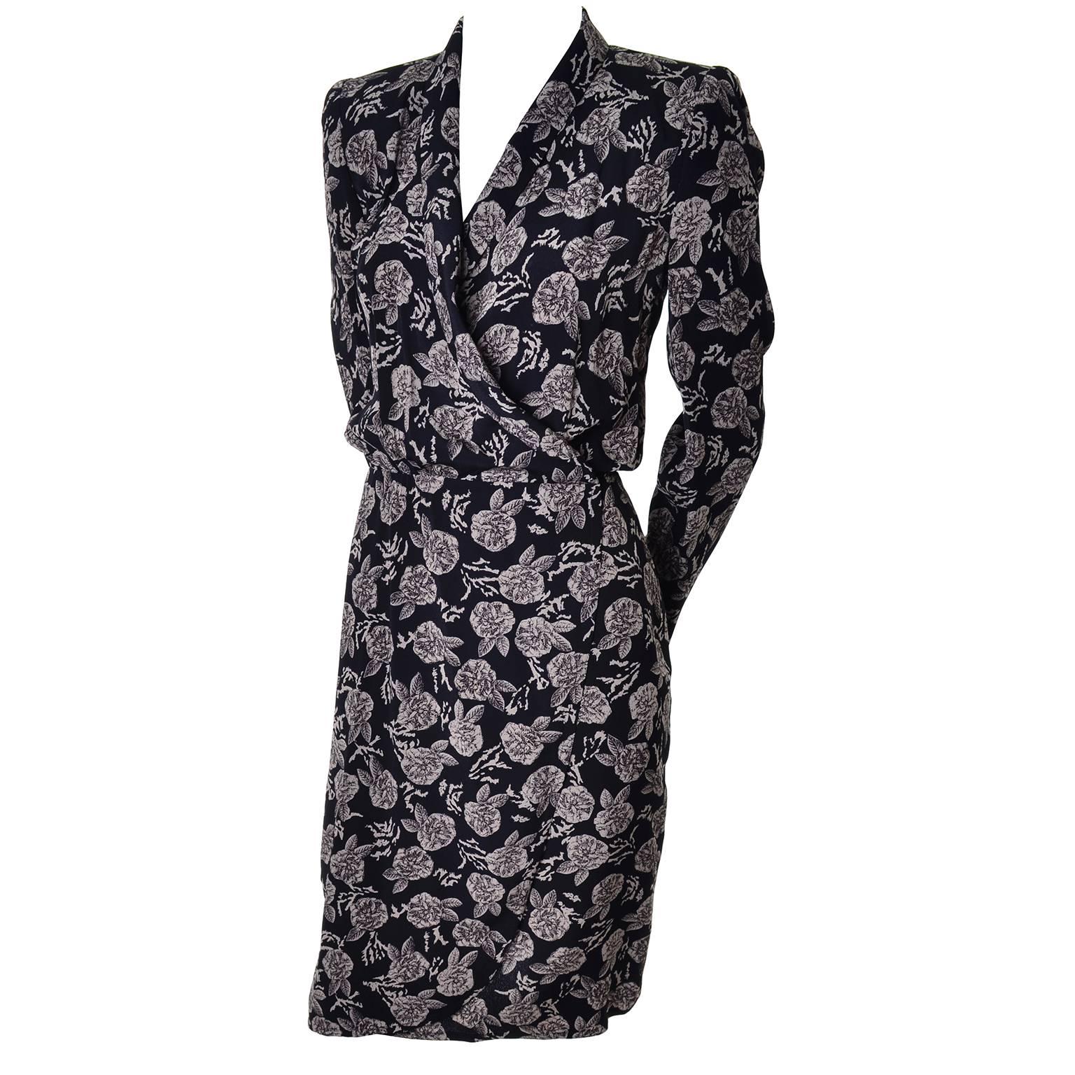 This late 1980's or early 1990s vintage dress is black with neutral colored roses and was designed by Sonia Rykiel. This floral wrap dress has one inner and one outer hook and eye closure, both at the waist. The dress is covered in tan/brown roses