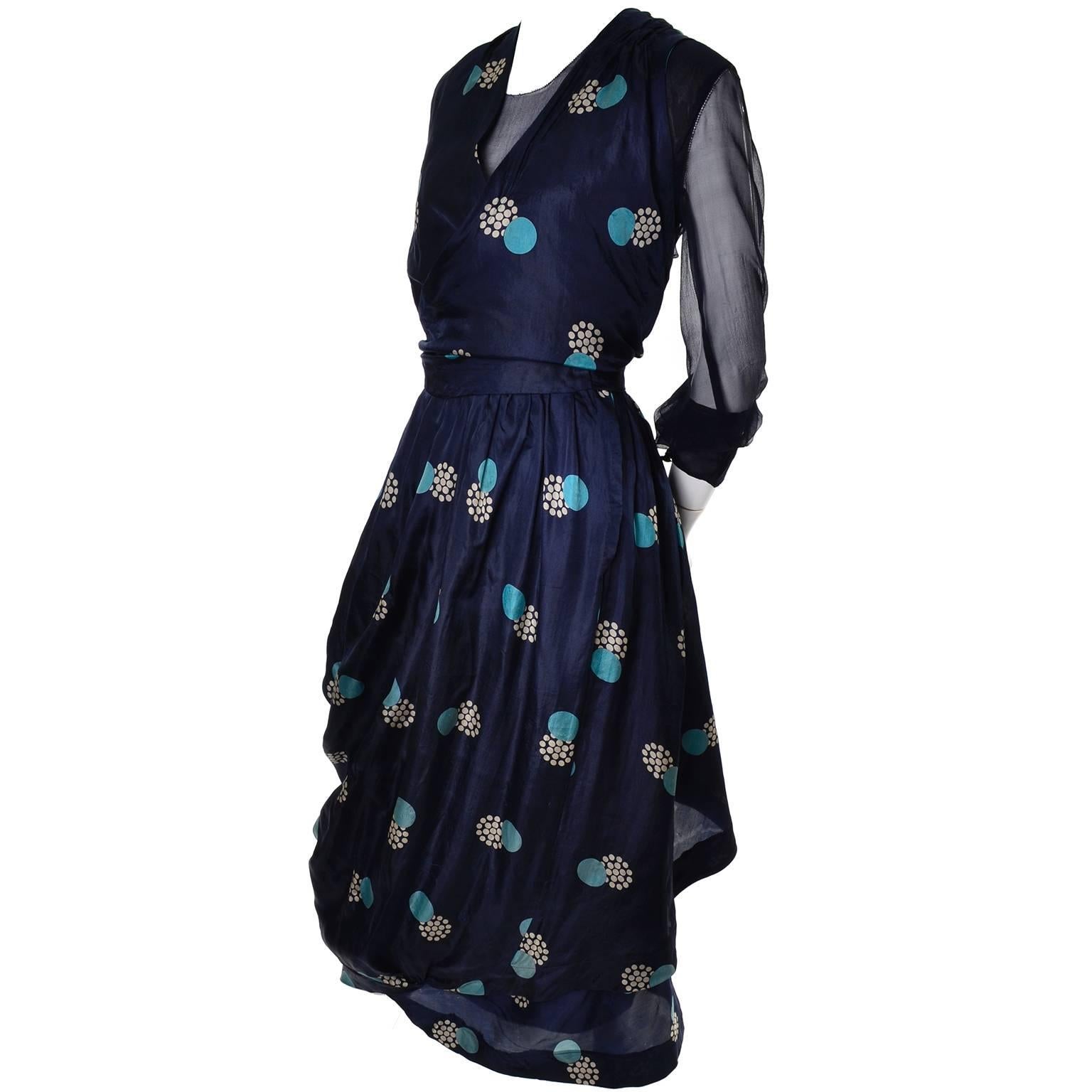This incredible dress is full of beautiful design elements from head to toe! This Edwardian dress is all one connected piece, but consists of three different layers. The top layer is the printed navy silk that has an abstract geometric circle