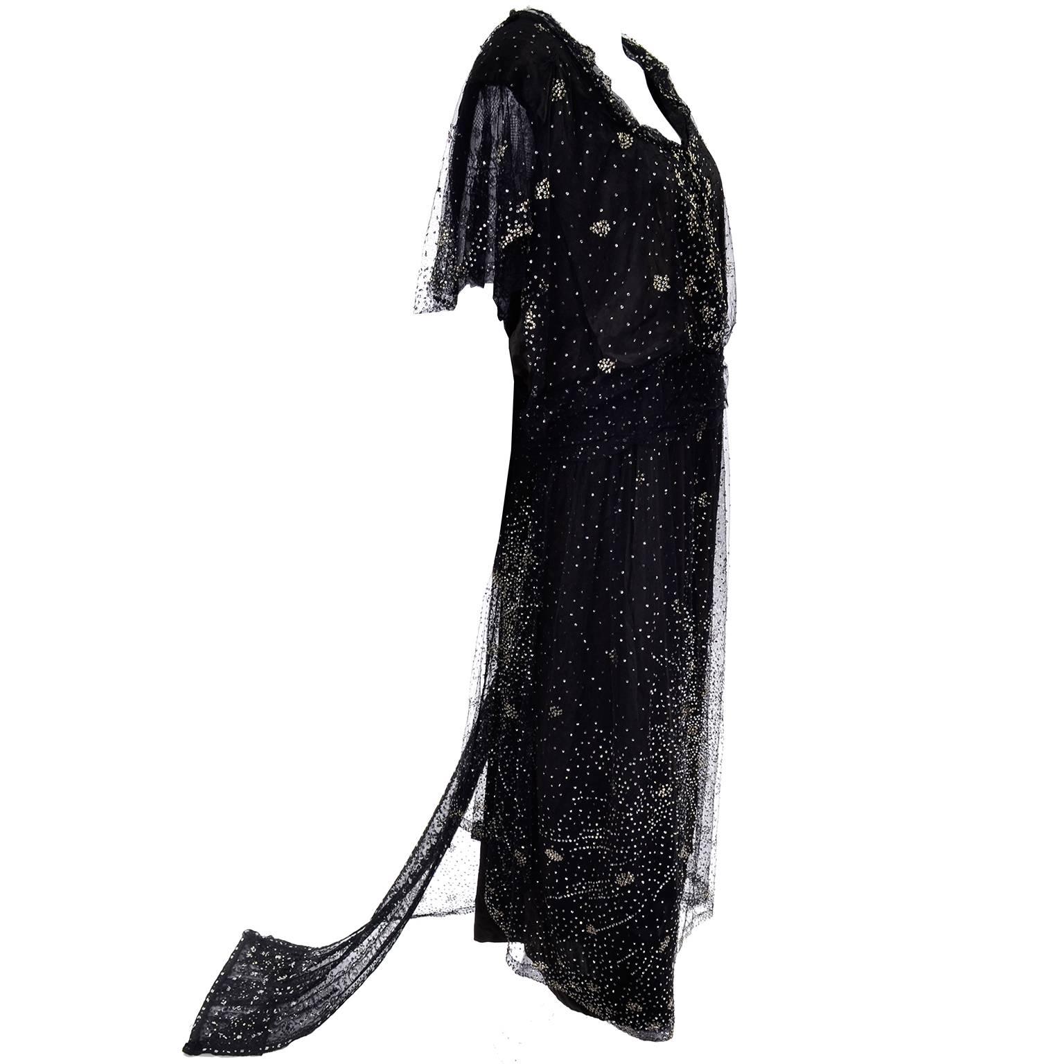 Il s'agit d'une robe édouardienne absolument incroyable avec des paillettes et des perles argentées recouvrant la couche extérieure en dentelle noire et créant un motif d'étoile en feu d'artifice sur le devant. La taille est ajustée par une sangle