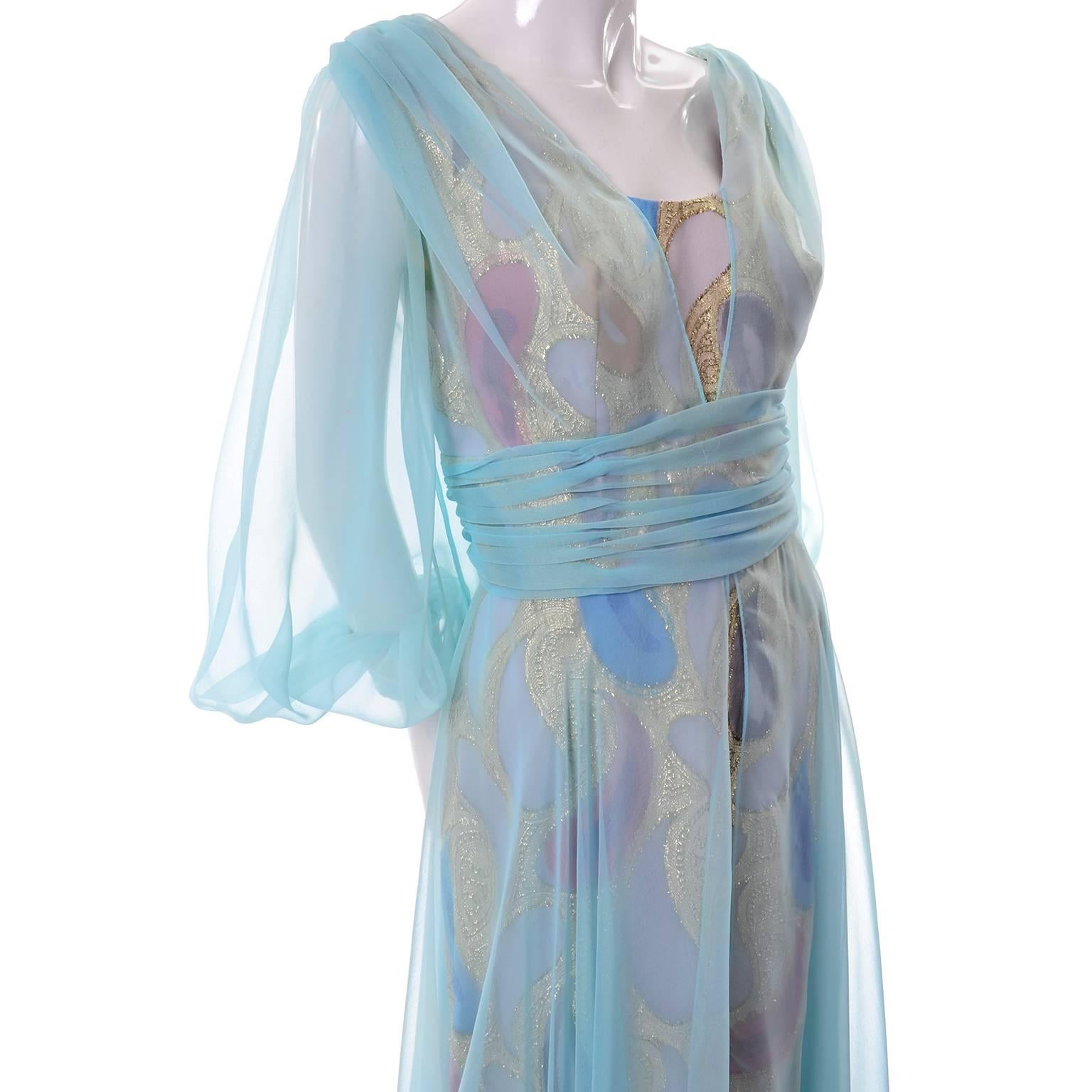 This sensational vintage dress was designed by Rose Taft for Couture Fashions in the 1960's. The dress has a sheer blue chiffon over a gold metallic fabric with pastel painted paisleys.  The dress zips up the back and has hooks and eyes, and has