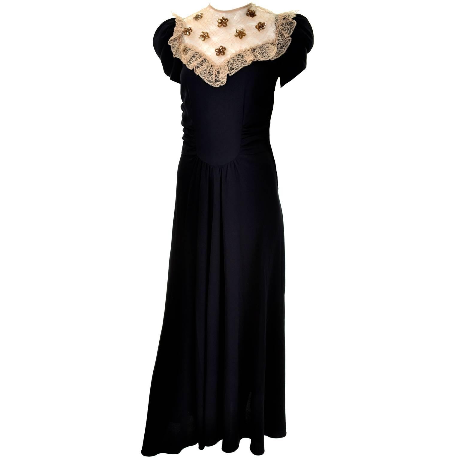 This is a wonderful vintage dress from the 1930's.  The dress is made of a black rayon crepe with a beautiful bodice that has gold netting and gold sequin flowers.  The sleeves are rouched and the dress has a back zipper. This evening gown is