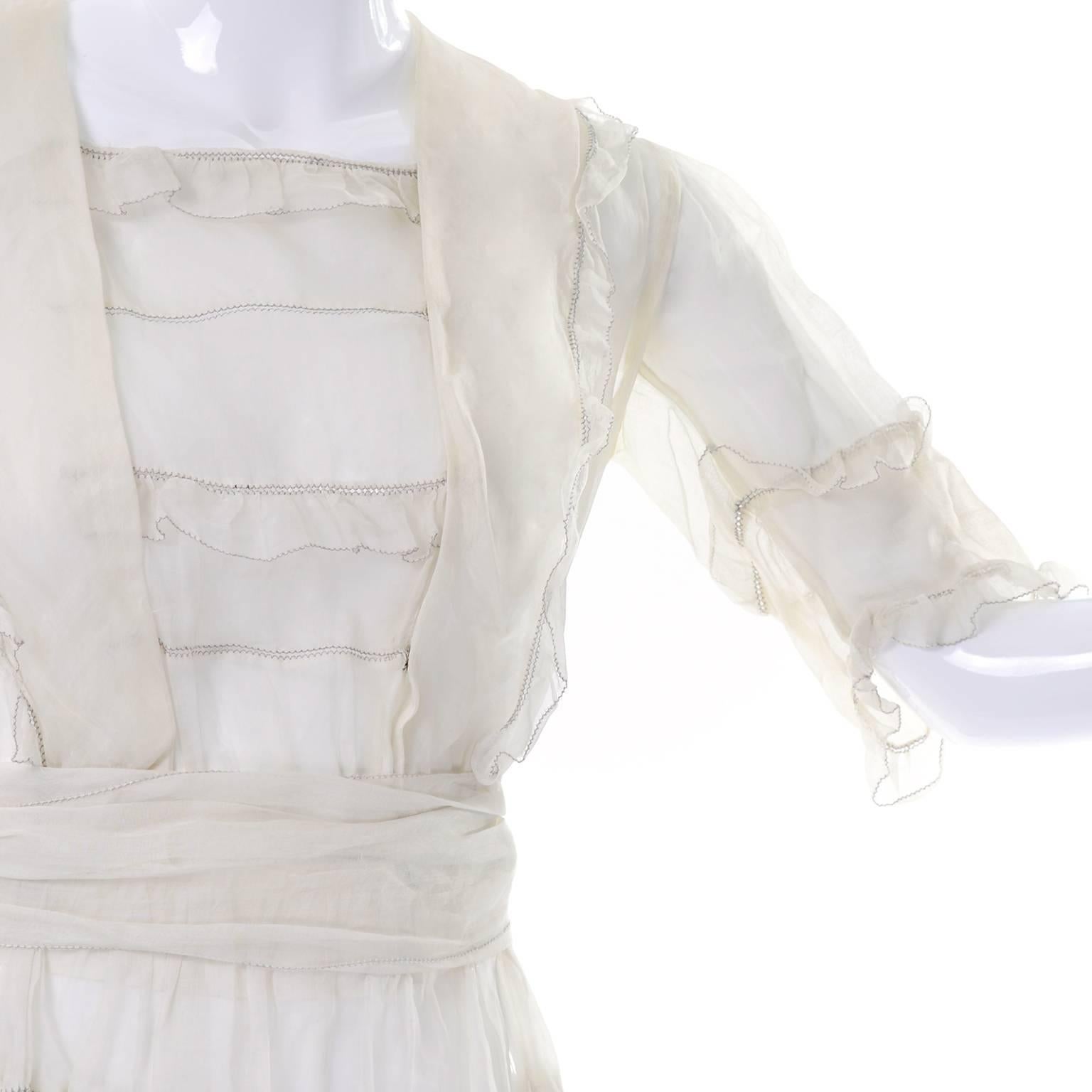 This is a beautiful off white vintage Edwardian organdy dress with ruffles and a sash. The dress has three quarter length sleeves , a snap in front panel and is sheer. We estimate this would fit size 4/6. This dress would make a wonderful wedding