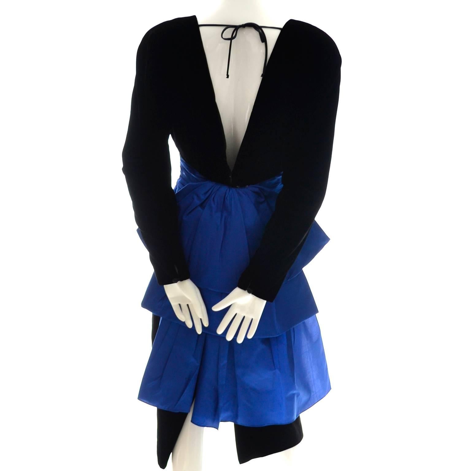 This pretty 1980's vintage A. J. Bari dress is made of a beautiful silk and rayon black velvet fabric and accented with blue taffeta at the waist. There are shoulder pads and the back of the dress ties at the neck and is open to the waist. There is