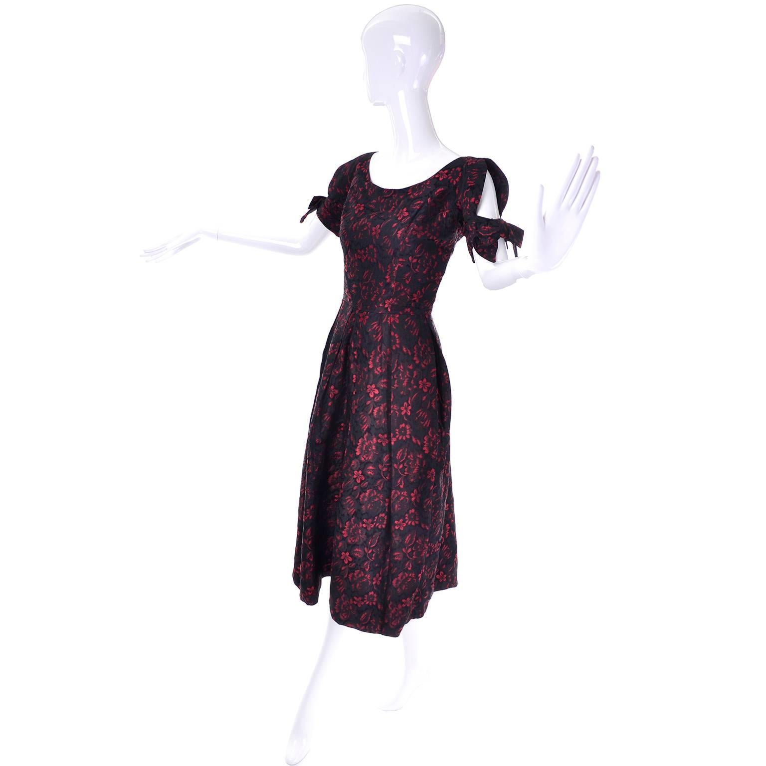 This is a wonderful vintage dress from Suzy Perette in a black and red floral brocade. This 1950's cocktail party dress has gorgeous sleeves with cutouts and it has an attractive, flattering fit.  There are two pleats in the front, that almost