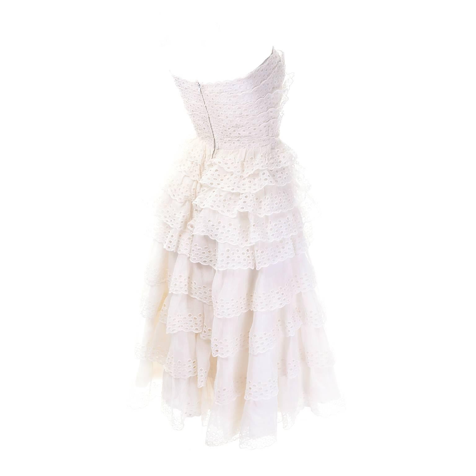 This is such a beautiful vintage white dress from Suzy Perette. There are layers of tiered eyelet ruffles with scalloped edges and six rows of eyelets along the edge of each ruffle. This strapless dress is fully lined, with 