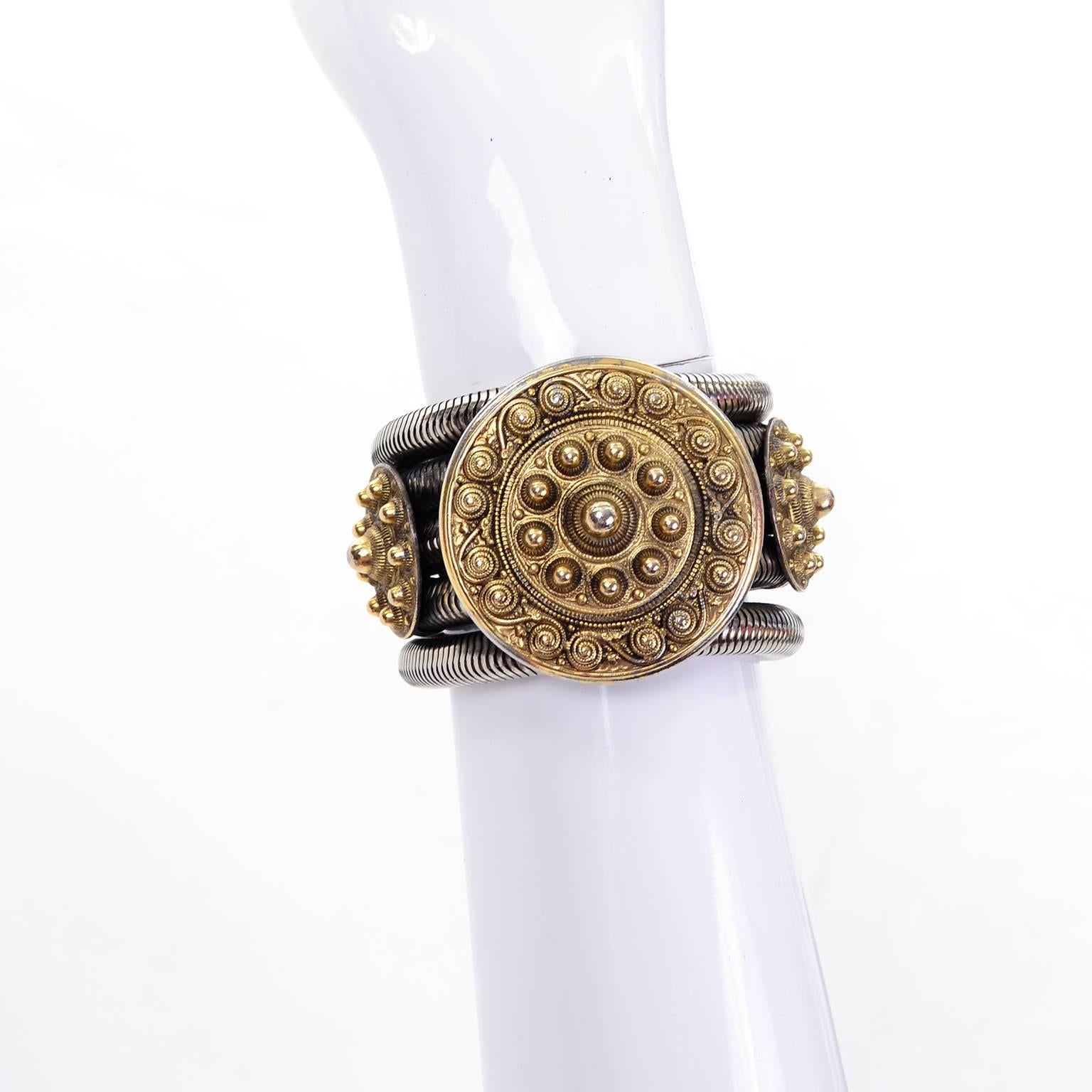Il s'agit d'un bracelet vintage unique et étonnant des années 1980 conçu par Edouard Rambaud Paris, composé de cinq serpentins en métal de couleur argentée reliés par trois cercles centraux de couleur or. Le cercle central est accompagné d'un cercle