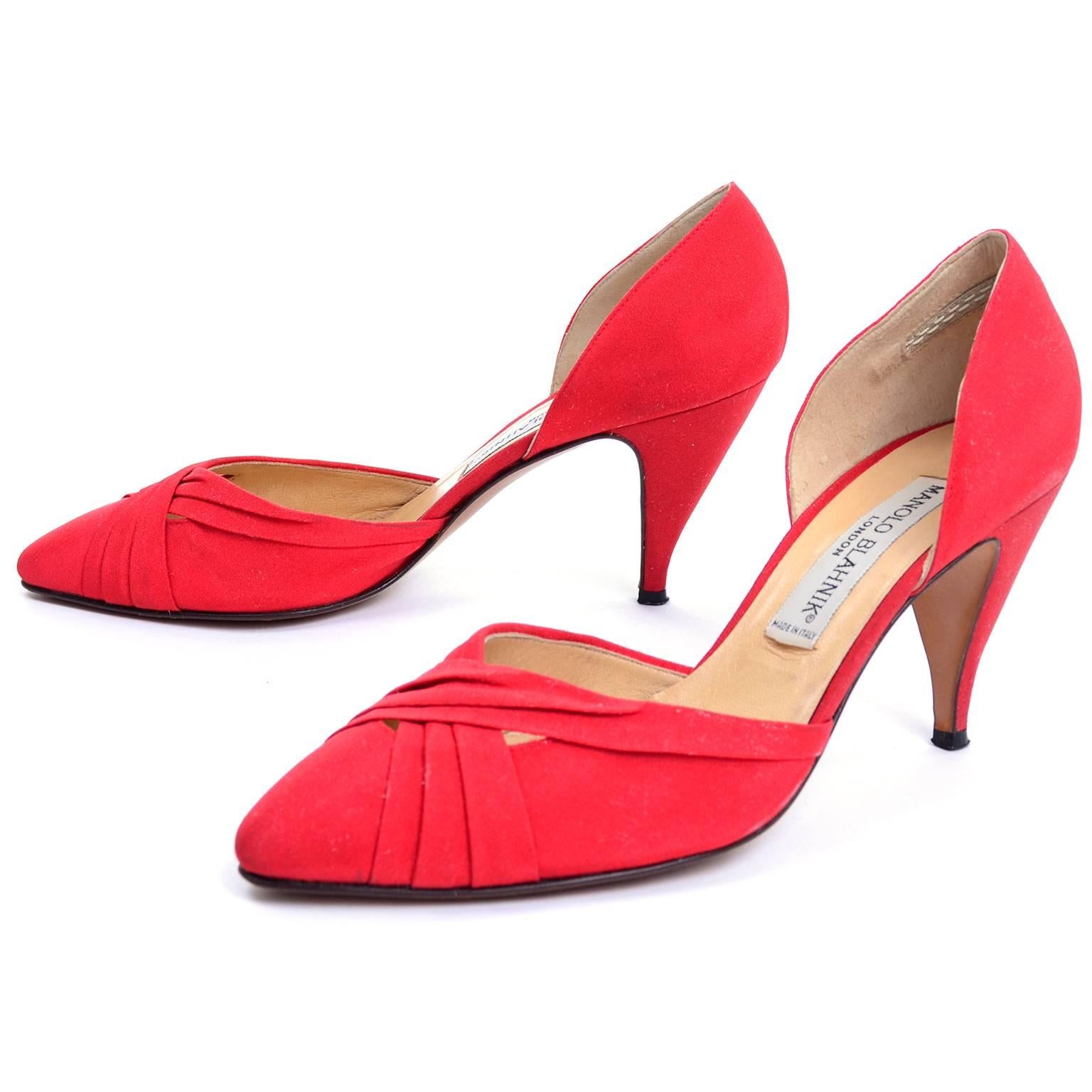 These are vintage red heels by Manolo Blahnik London with pleated fabric that criss crosses over the upper and a leather sole, made in Italy. These vintage shoes have only a small amount of wear on the soles, and one scuff on the inside right heel.