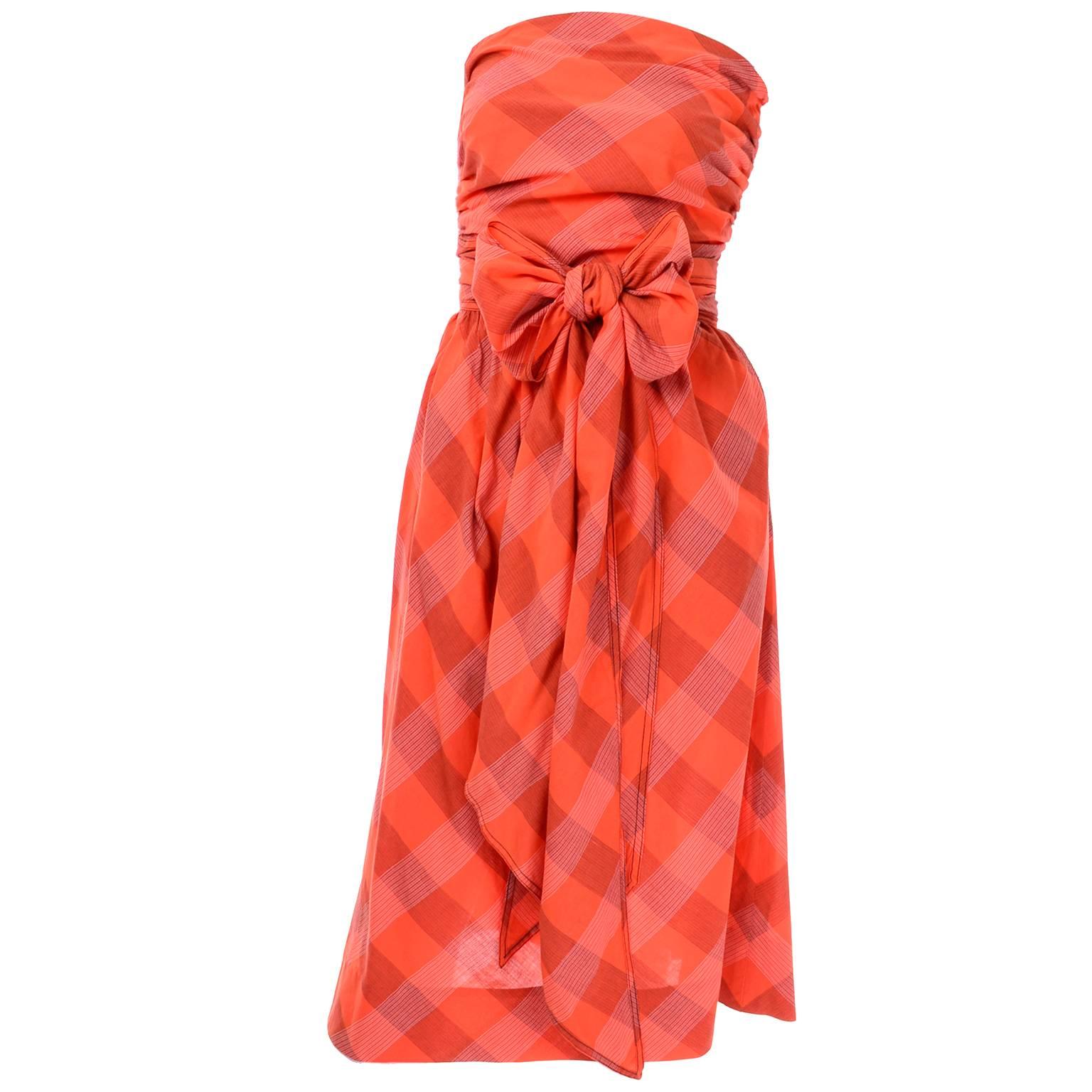 This is a gorgeous Claire McCardell vintage orange plaid cotton dress. This strapless dress closes with a side zipper at the waist and has a long attached sash that can be worn in many different ways. The dress has both the Claire McCardell clothes