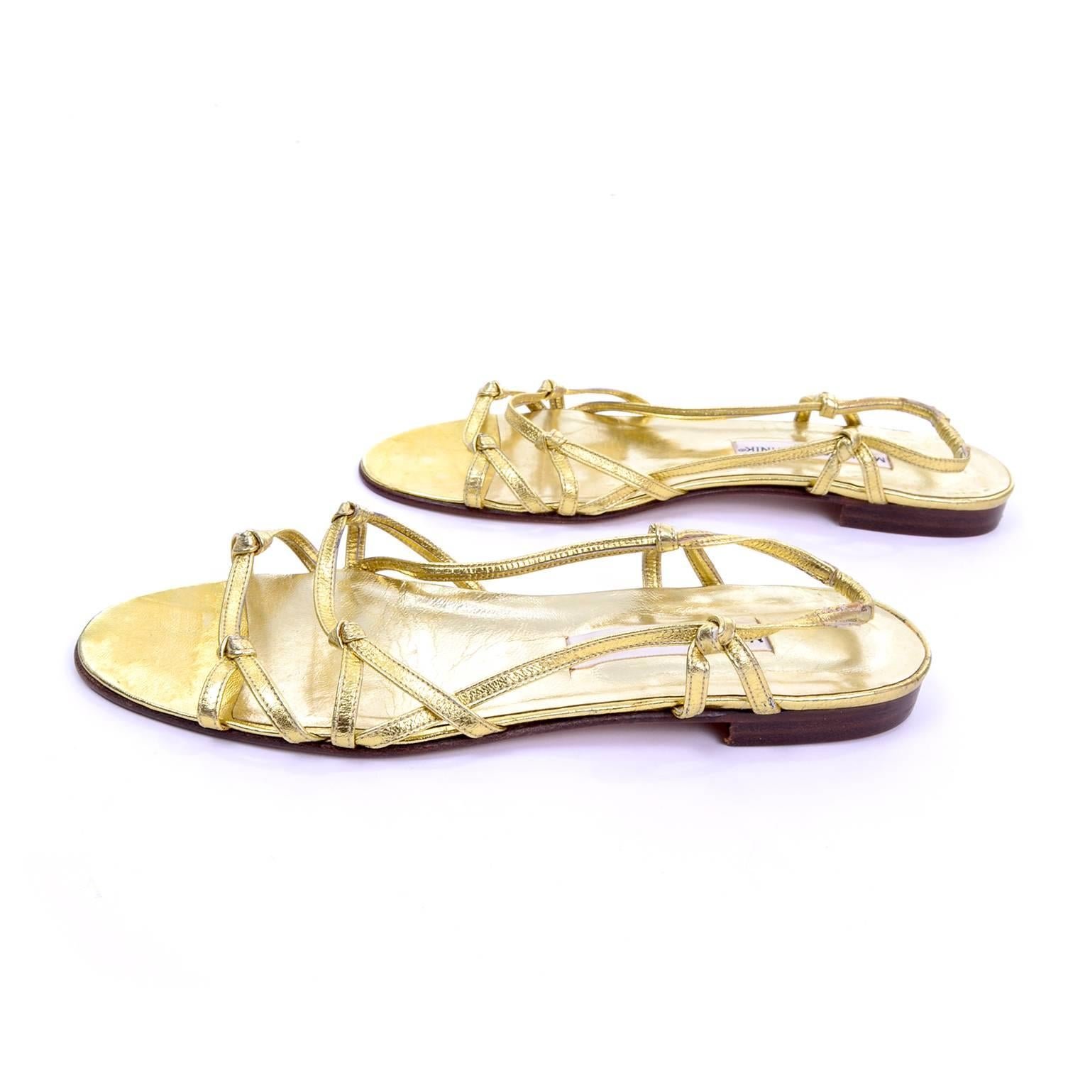 These summer slip-on sandals by Manolo Blahnik London have two knotted gold leather straps across the upper, and an ankle strap that is knotted on each side, with elastic on the back. These sandals have leather soles and have never been worn. They