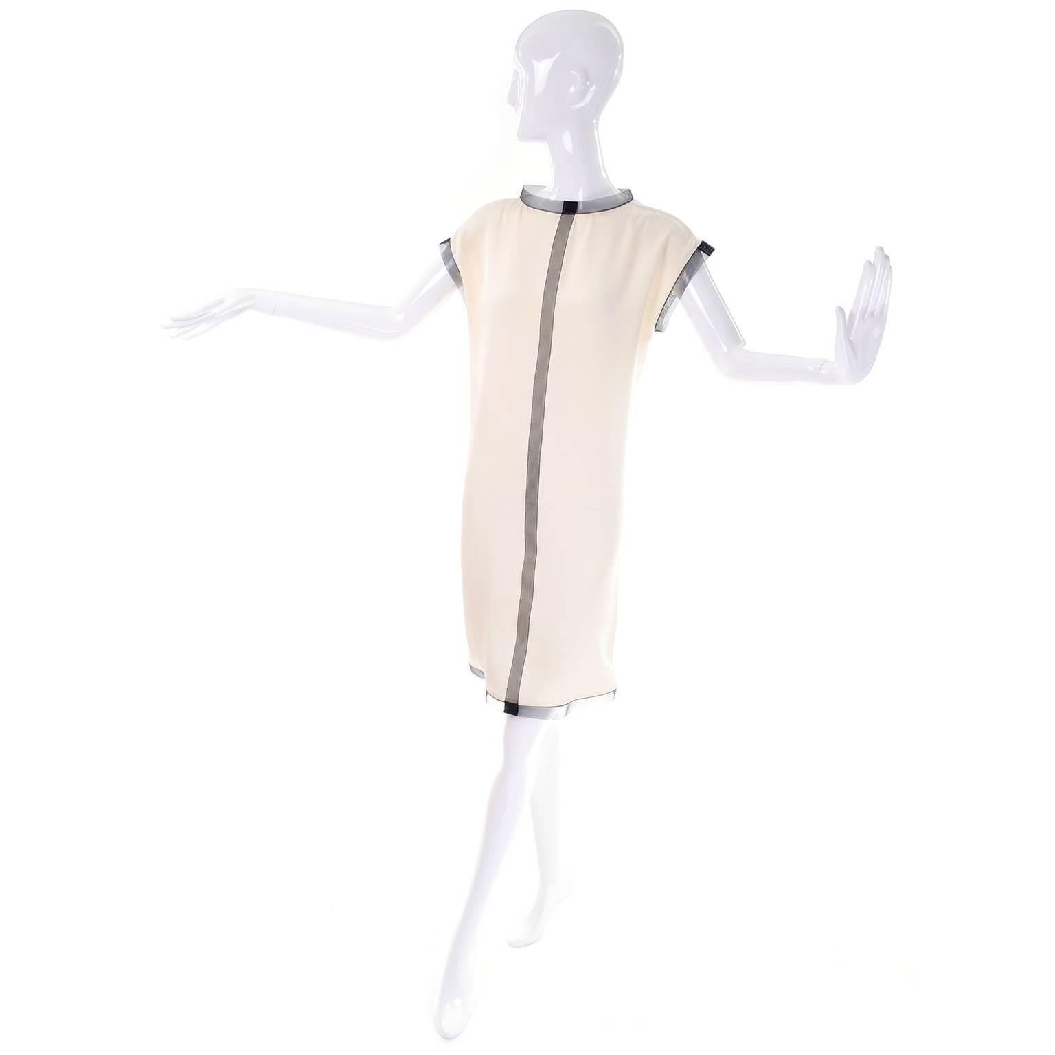 This beautiful vintage 1990's ensemble was designed by Geoffrey Beene in the 1990's. This outfit includes cream silk dress with black net trim, and a cream sheer mesh like coat with black net trim.  This outfit was purchased at Neiman Marcus and we