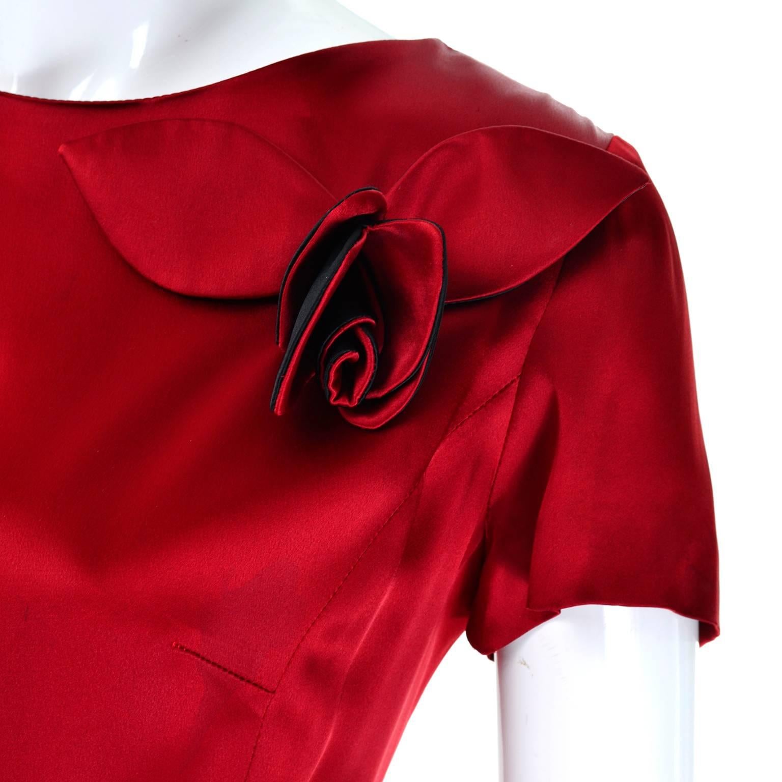 This is a great Moschino Cheap and Chic vintage silky red and black dress with 3d roses and a slight peplum. There is a zipper in the back at the waist and covered buttons on the top below the neck. The dress is approximately a modern day size 8/10