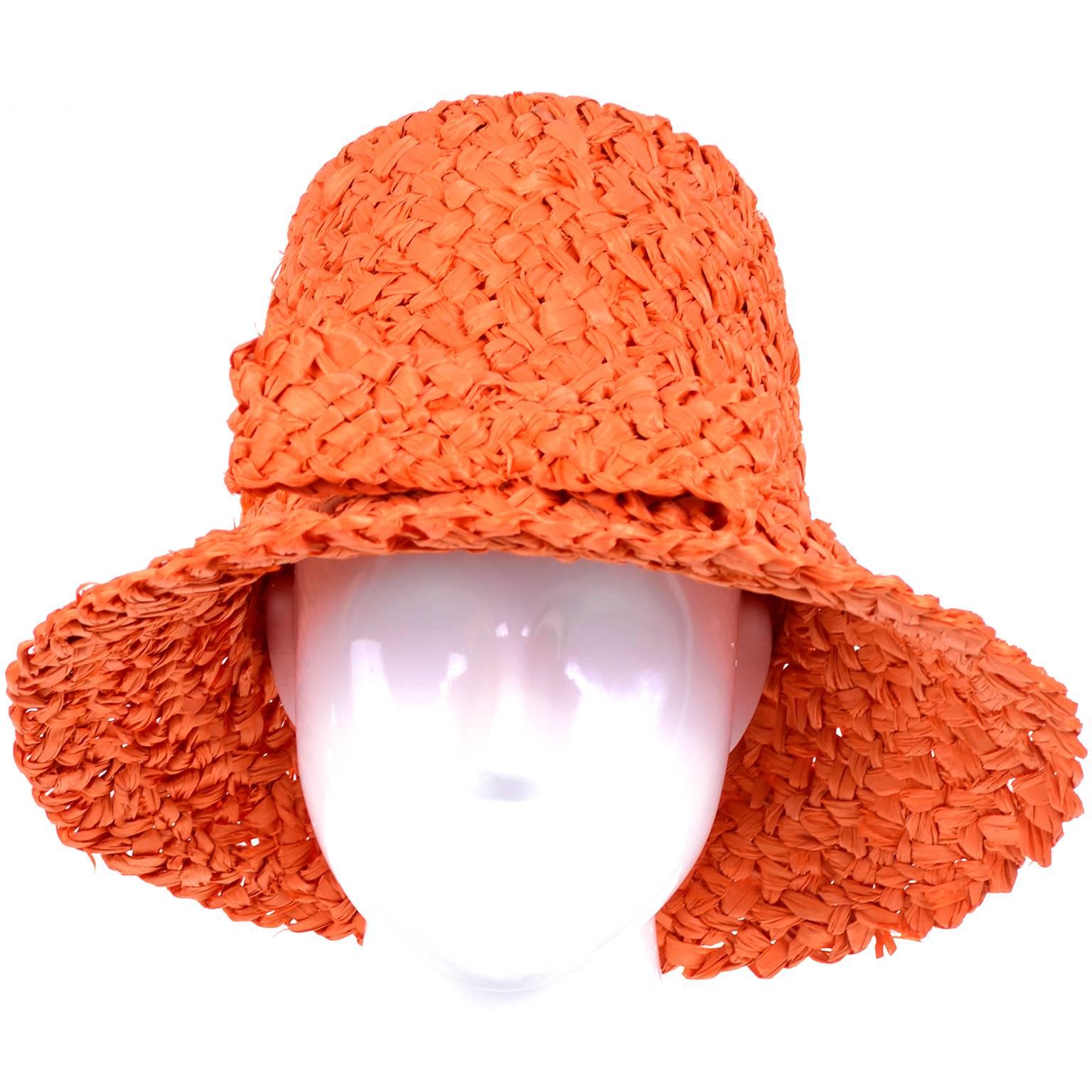 This hat is so reminiscent of images from Vogue in the 1960's with models sitting on the beach in swimsuits and wearing hats just like this one!  This is a tall vintage orange straw raffia hat that measures 6