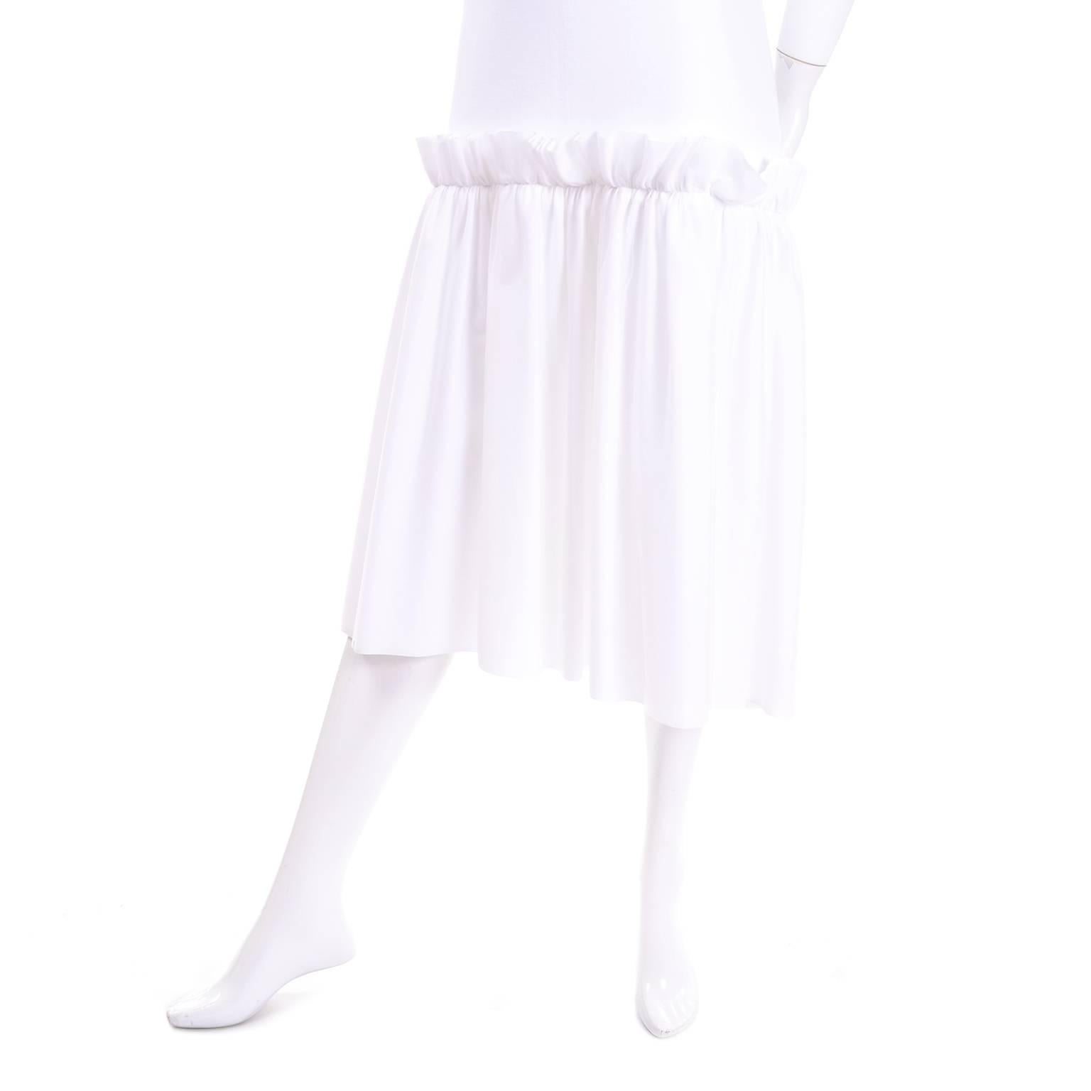 This is a great white cotton minimalist Simone Rocha t-shirt dress with a fine layer of white tulle over the skirt. This dress has both the Simone Rocha and the Ikram Chicago store labels. The dress appears to be unworn and fits approximately a US