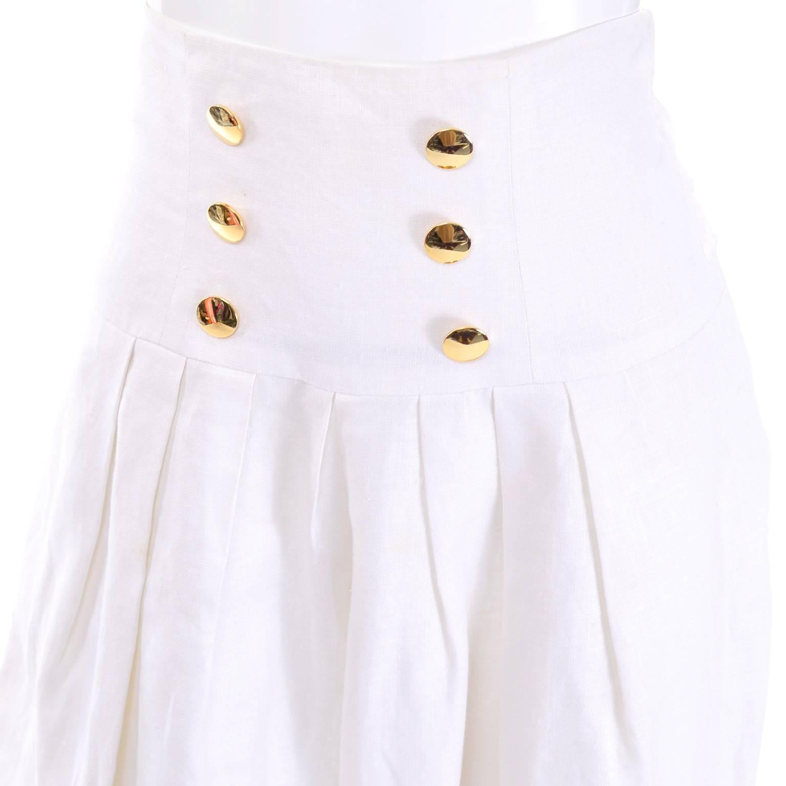 These high waisted vintage Nipon Boutique white sailor style pants are made in a beautiful off white linen. These wonderful pleated trousers have wide legs with pleats and three navy blue stripes at the cuff. There are six gold tone decorative