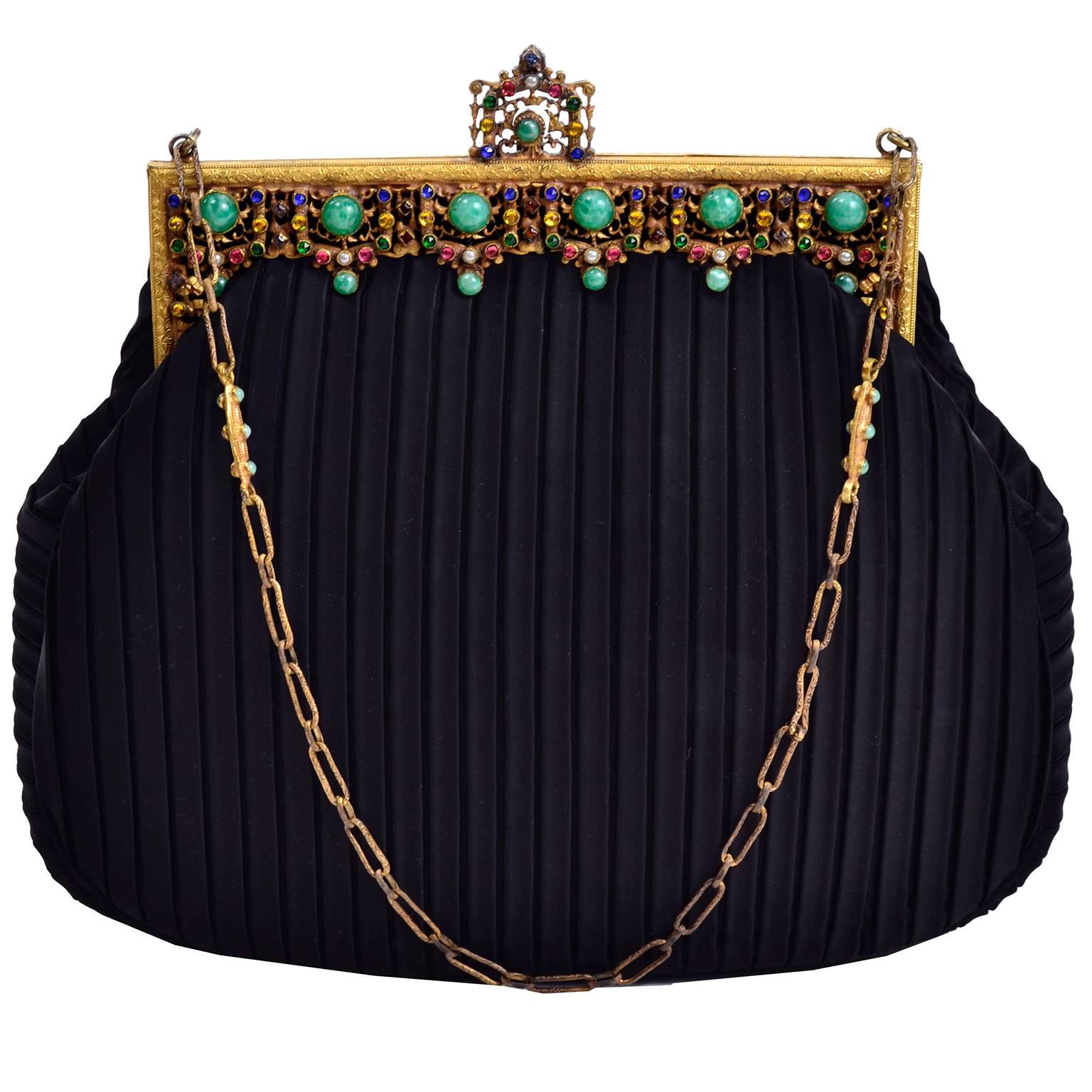 This is a lovely vintage handbag with black pleated matte satin and a gorgeous jeweled gold frame.  The bag has a metal strap with beads that has a 8