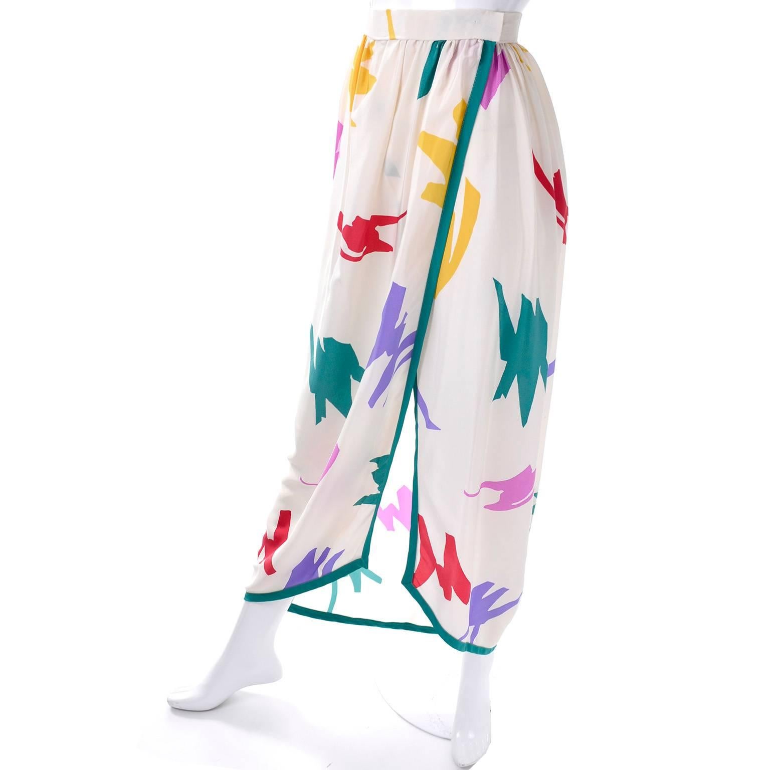 This pretty vintage Oscar de la Renta silk skirt is from the late 1970's or early 1980's.  The skirt has a multi colored abstract jewel tone design on ivory and green trim.  The skirt has 2 hook and eye closures at the waist and is labeled a size 8