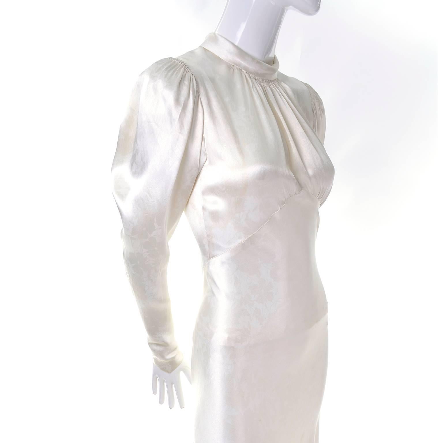 This beautiful ivory silk satin tone on tone floral patterned wedding gown is from 1939.  The dress has covered buttons up the front and on the pointed sleeves, a lovely train, and a gathered high neck that is somewhat reminiscent of Mainbocher's