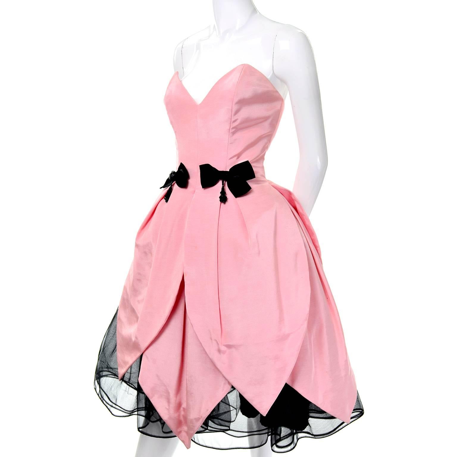 This is an incredibly fun petal pink strapless vintage Victor Costa dress that was purchased at Bergdorf Goodman in the 1980's. It has boning in the bodice, and two black bows at the waist that have beads hanging from the center. The full skirt has