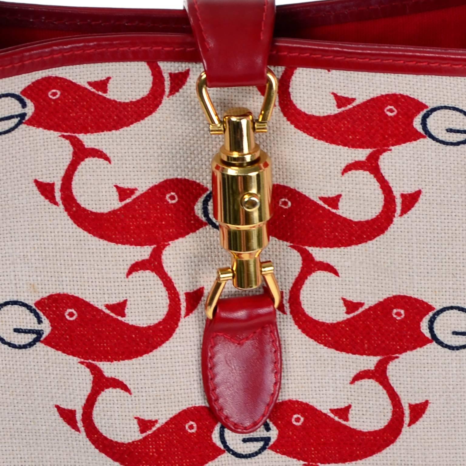 This is a wonderful vintage handbag from Gucci in an off white, (almost sand) and red whale or dolphin print canvas with red leather trim. This handbag measures 7x10.5