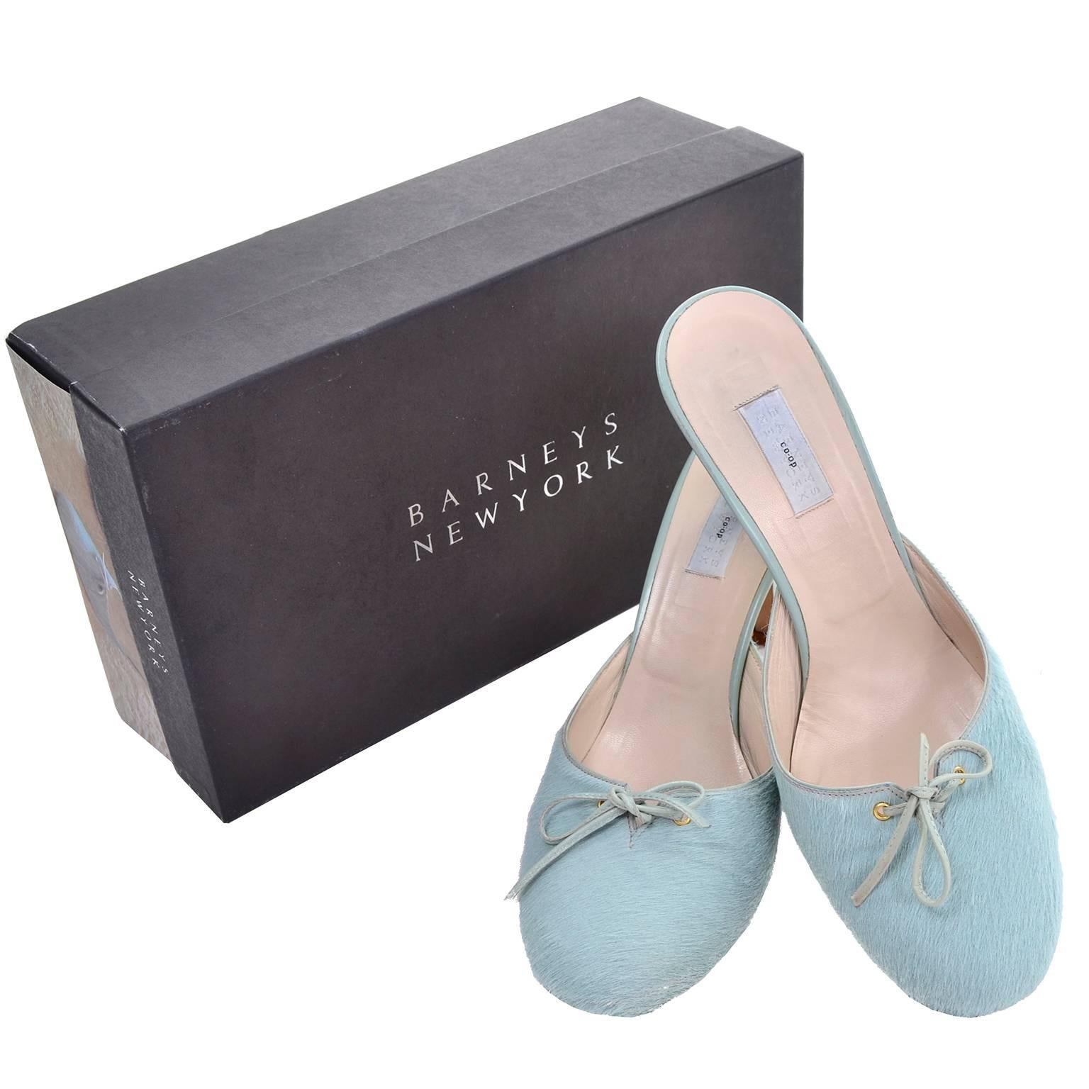 These Barney's New York blue pony fur backless mules or slides have leather trim heels and pretty leather bows. These shoes are labeled a size 37 and were made in Italy. These are 3.25