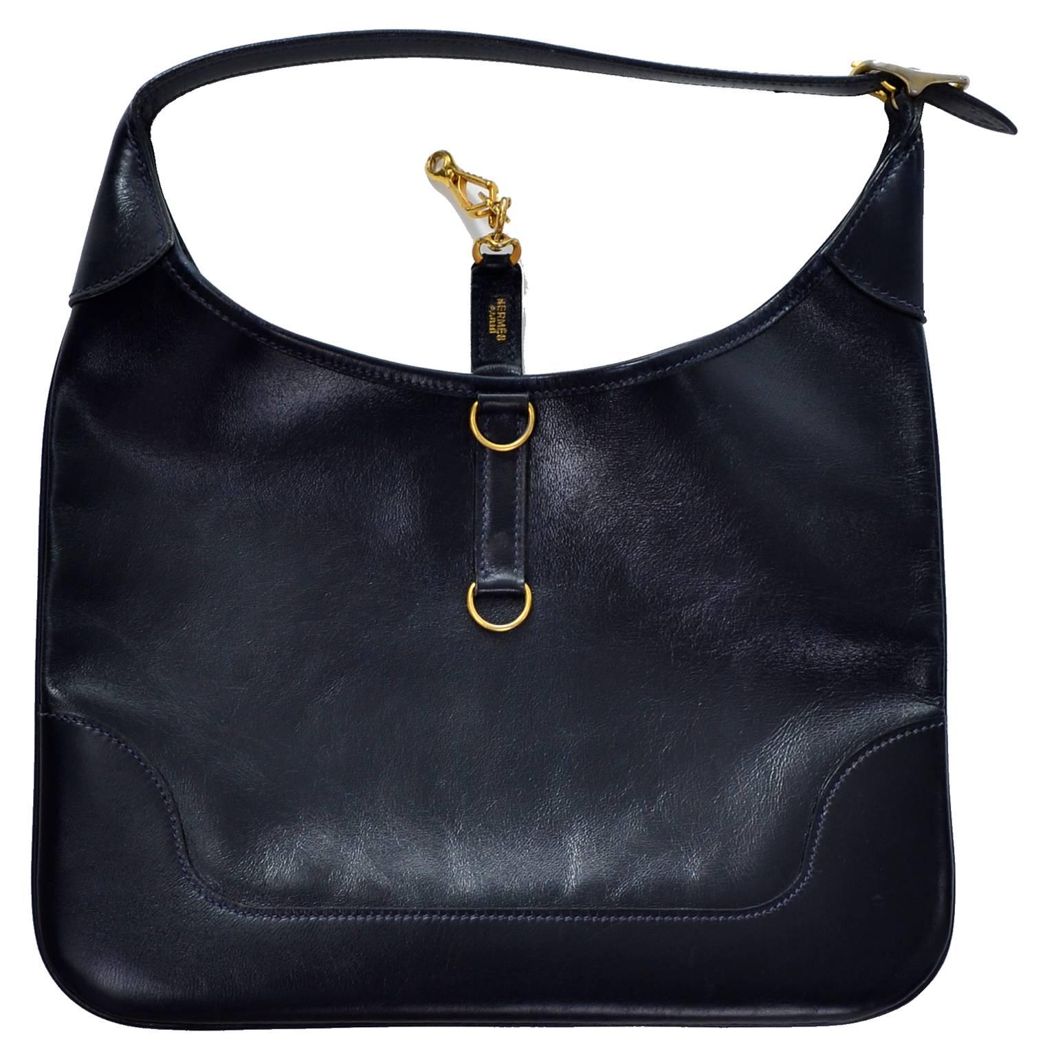 This is a beautiful 1970's vintage Hermes handbag made of a midnight blue leather with a gold tone lobster claw clasp and tonal suede interior. The leather is called box calf, named after Joseph Box, a 19th century shoemaker. 

The strap has a