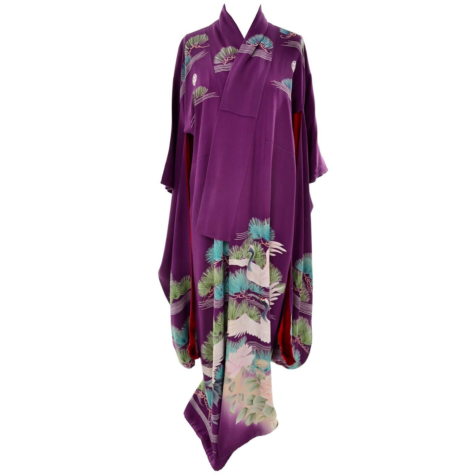 This is a stunning 57" long, hand sewn purple silk Kimono with gorgeous Yuzen dyed green and aqua pine trees with large white cranes.  The kimono has 5 family crest Mons; one on each sleeve, one at the back of the neck, and 2 on the front.