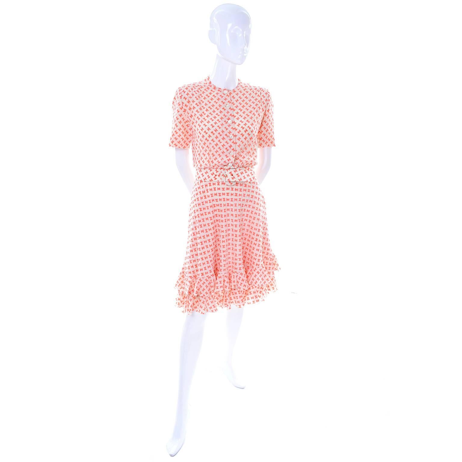 This couture vintage dress is in ivory silk with a fabulous orange bow print and it comes with its original fabric belt. There are moon glow type buttons up front and a side metal zipper. This perfect Spring or Summer  dress is lined and has a