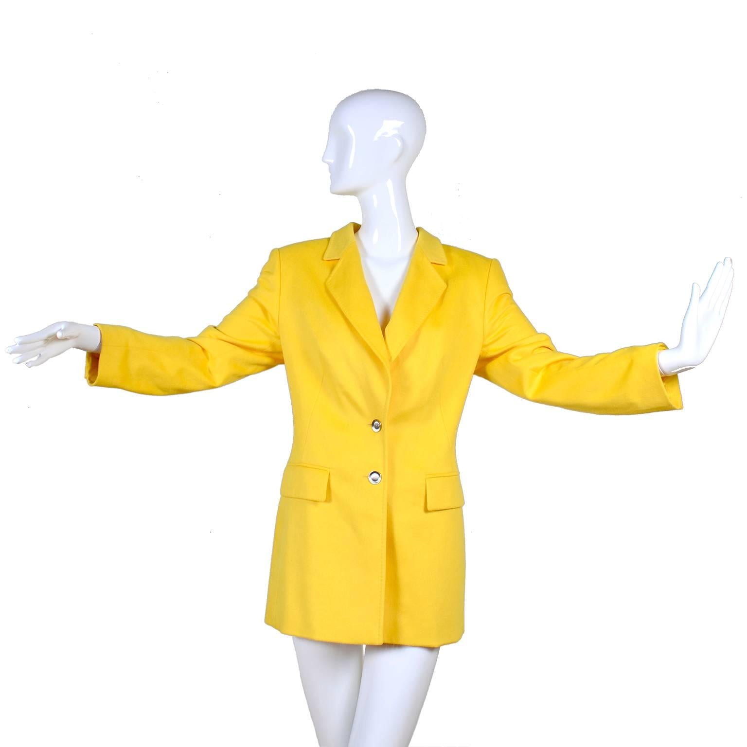 This beautiful early 1990s yellow Escada blazer still has its original tags and extra buttons attached.  The jacket was designed by Margaretha Ley and is 70% Rabbit and 30% new wool. The logo lining is rayon and there is aksi an inner label that