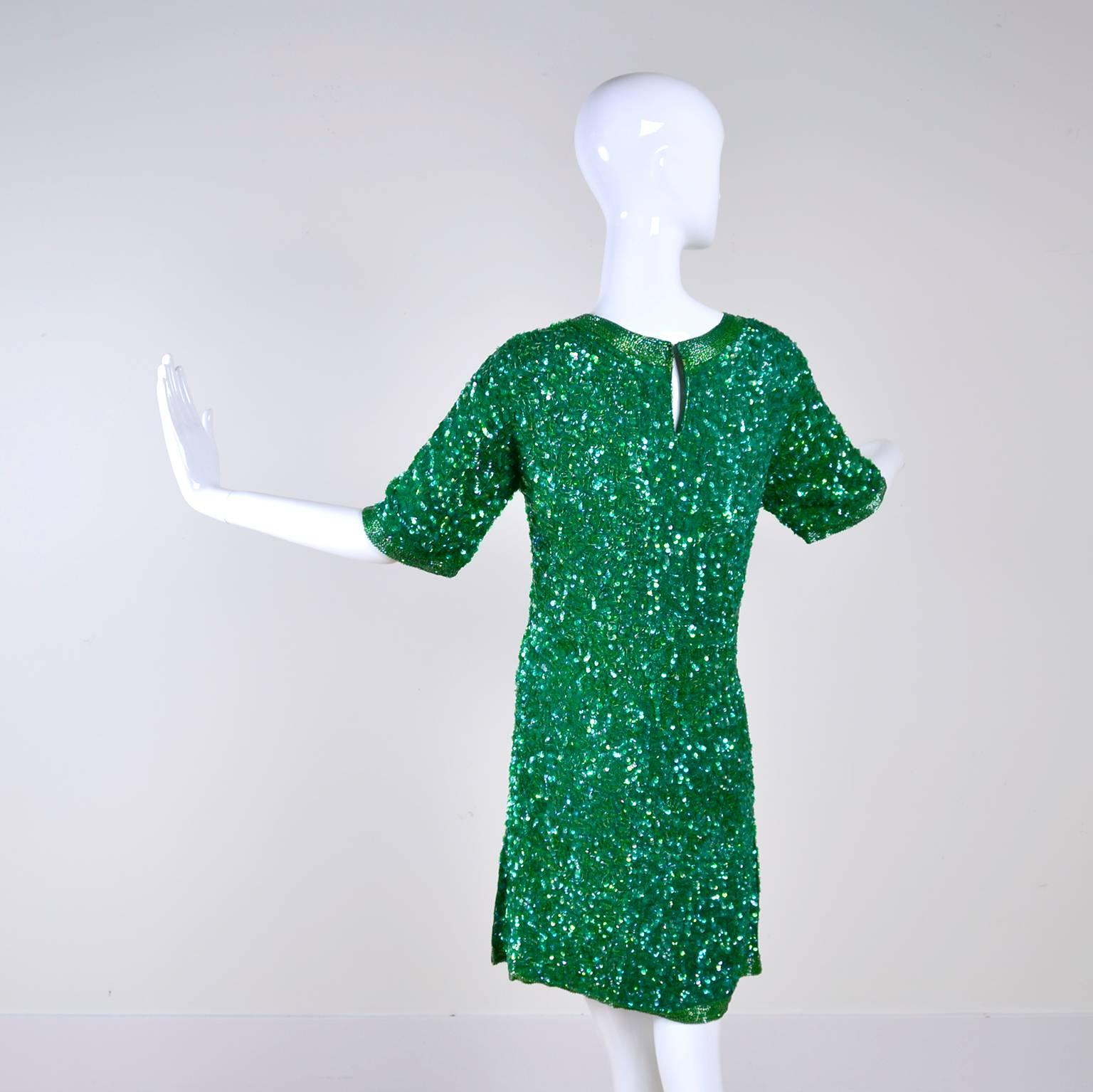 This pretty green sequin and beaded silk dress is a great dress to add to any wardrobe!  The dress has short sleeves and is lined with rayon. There is a back hook and eye at neck and there are beautiful rows of beading at the hem of the sleeves and