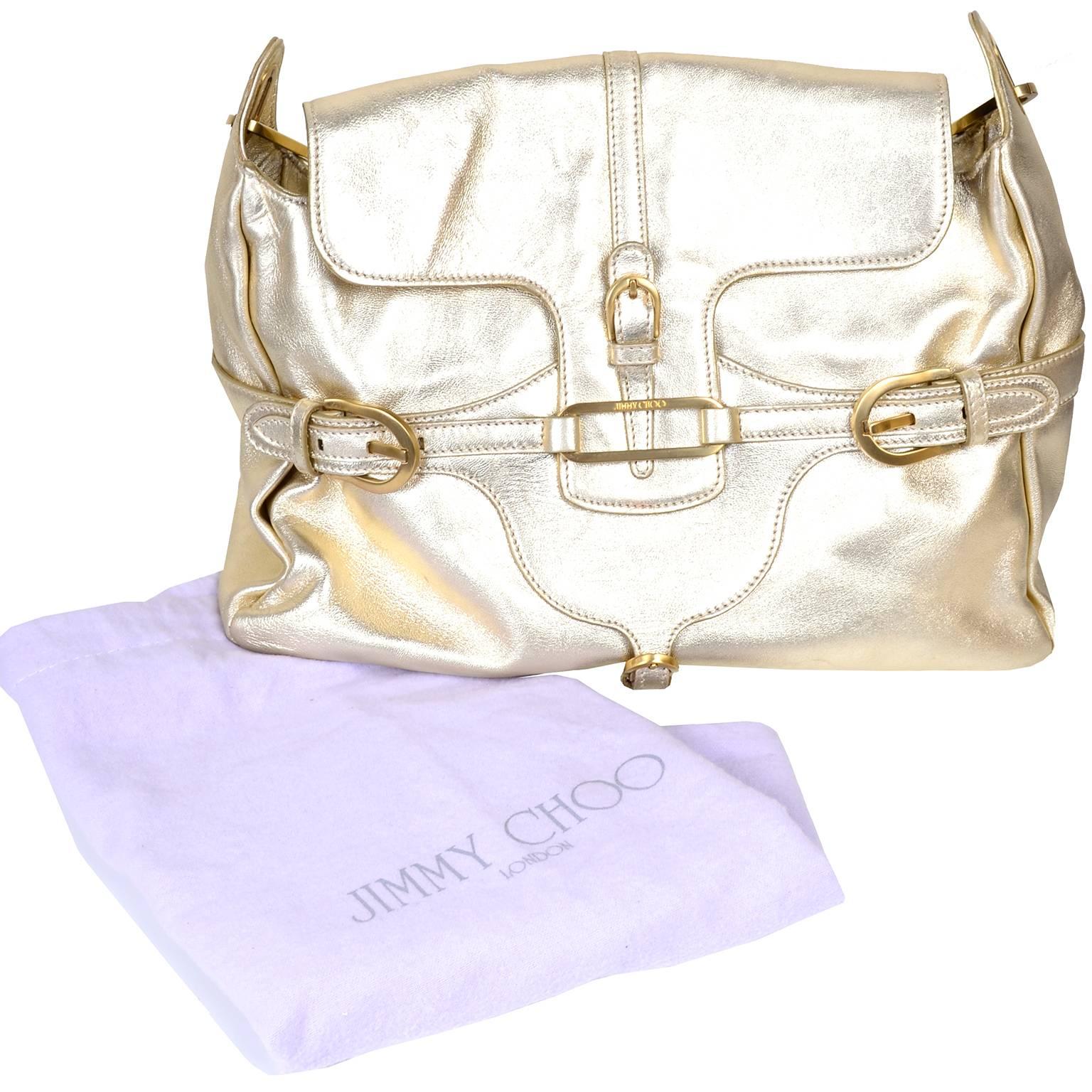 This is a great late 1990s or early 2000s Jimmy Choo gold metallic leather handbag with wonderful gold hardware.  The bag has 3 inside flap pockets, one zip pocket and its original dust bag. This bag measures 14” across at the bottom, 10” high and