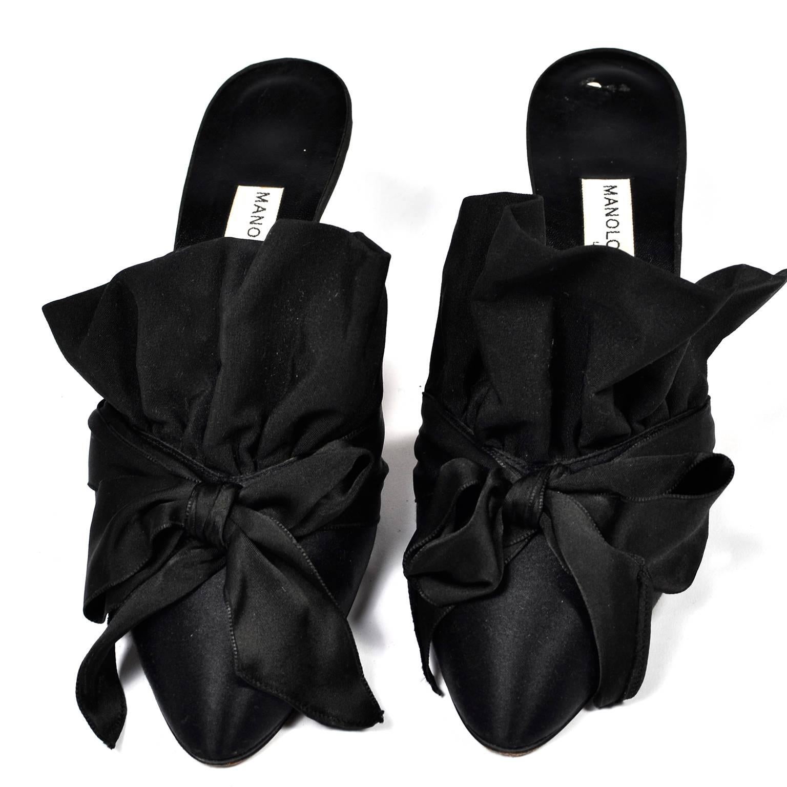 These are rare 1980s Victorian inspired Manolo Blahnik mules with ruffles in size 39.5.  These fabulous black satin shoes have 3" heels, and measure 3" at widest part of the outside of the soles.  We love the bows and the flare heel!