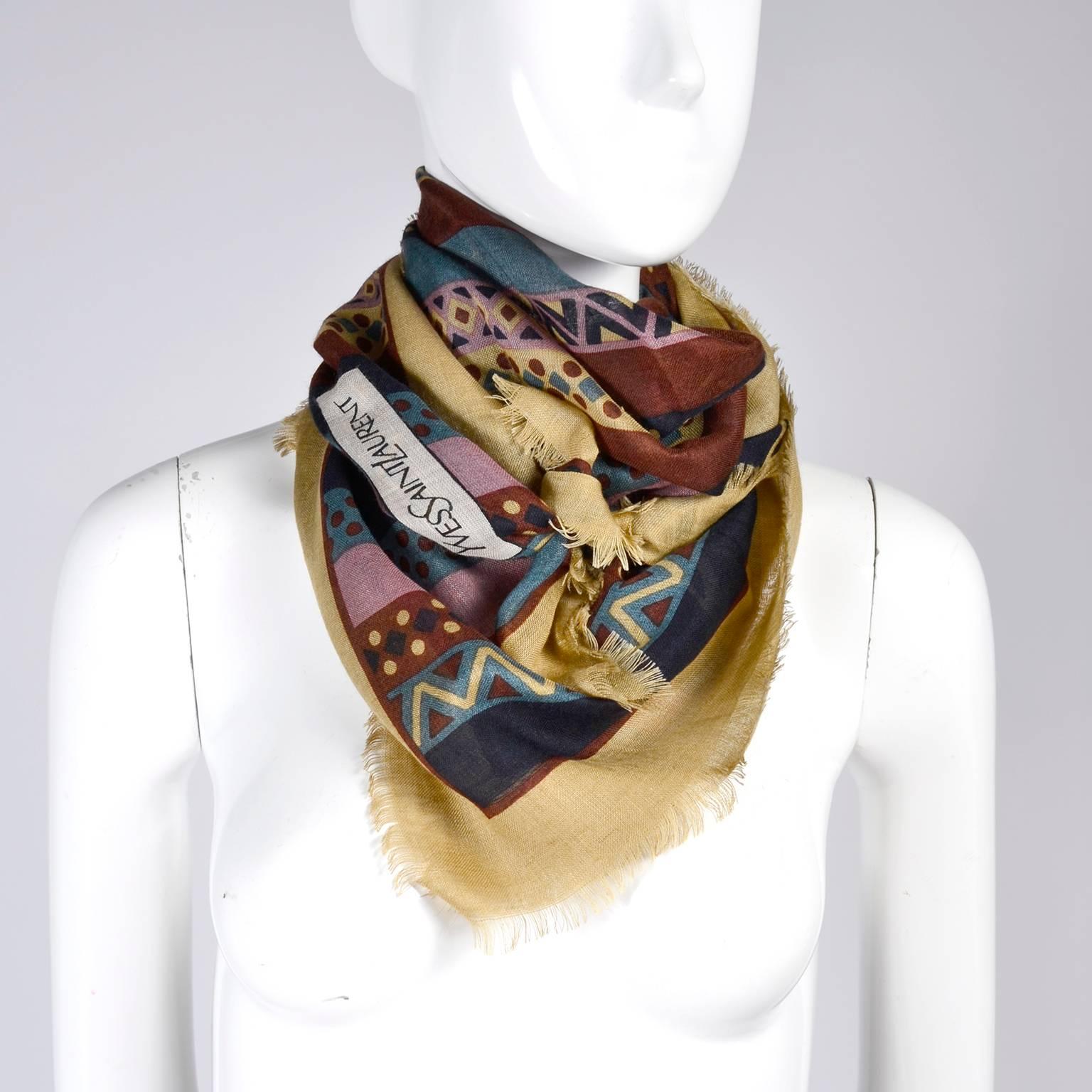 This is a wonderful very fine wool 34" SQUARE vintage Yves Saint Laurent scarf with great geometric patterns and 1/4" fringed edges. The colors are a beautiful palette of rich burgundy, wheat, blues and purples.  This YSL scarf can be worn
