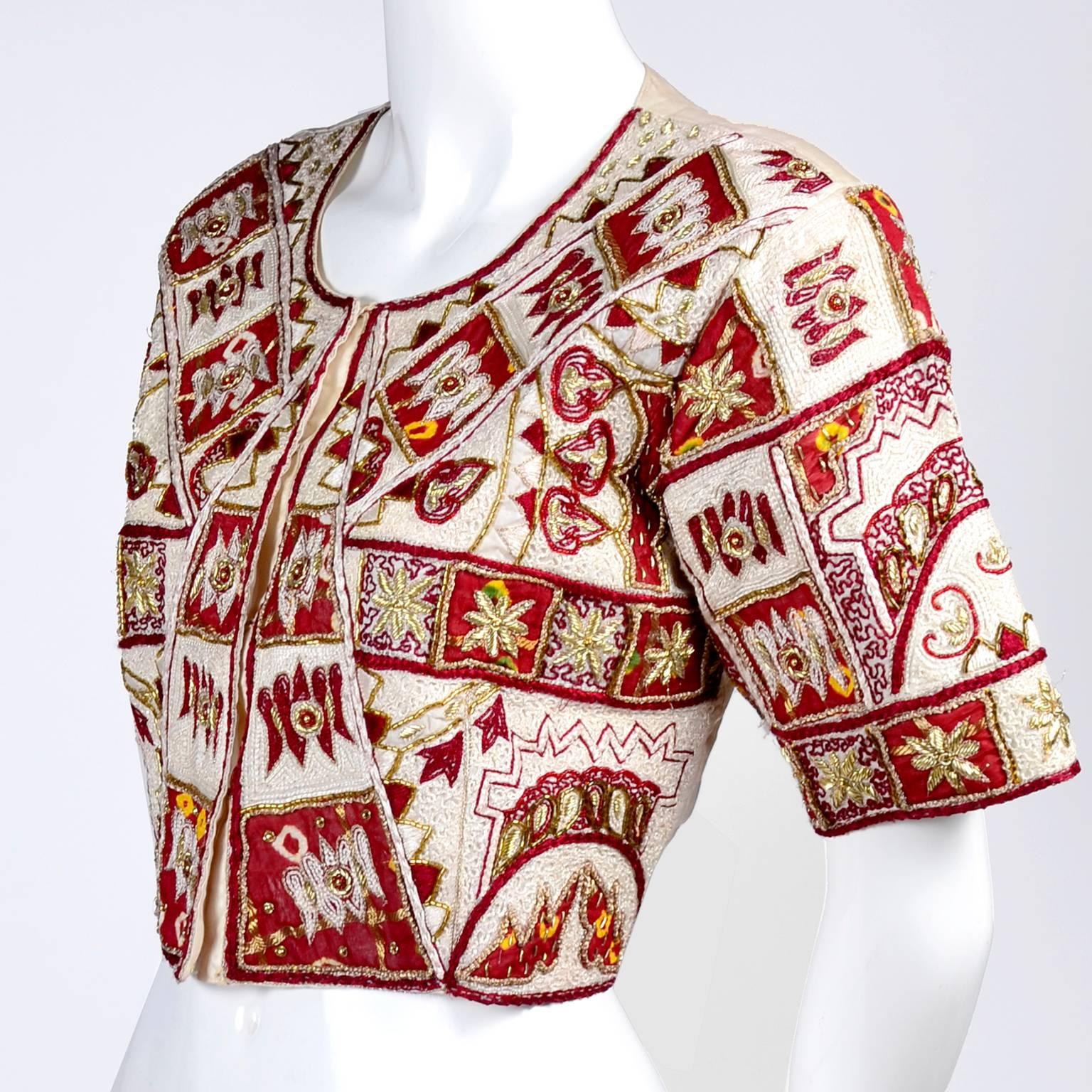 This is a beautiful vintage Choli or Saree/Sari top is made in a creamy ivory silk and has intricate embroidery over the entire front.  This lovely older Indian blouse has squares and designs in maroon, with gold metallic embroidery throughout and