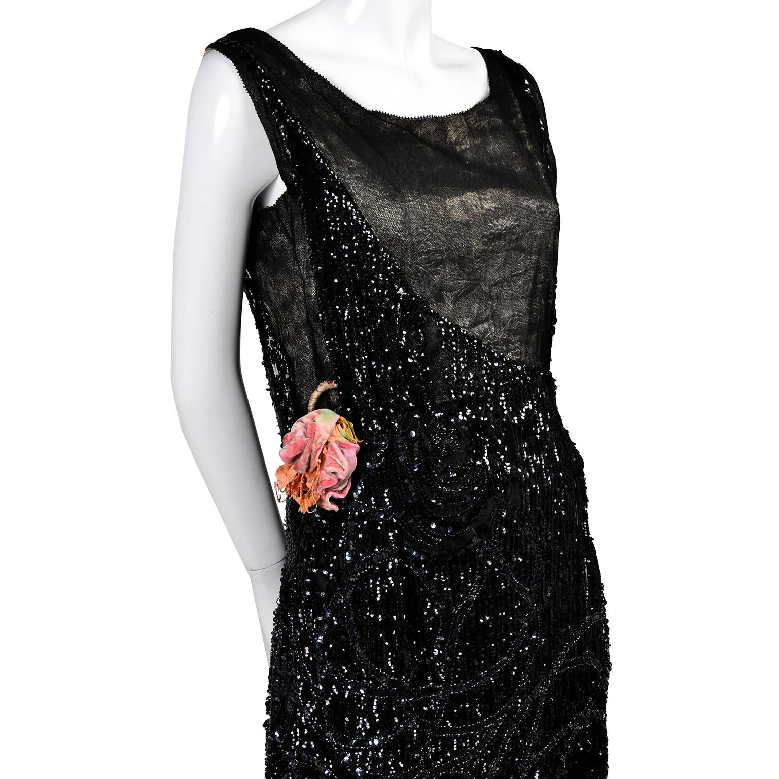 This beautiful 1920's vintage dress is covered in sparkling sequins and also has some rows of tiny beads.  This dress has an interesting bodice with a metallic black fabric on the diagonal on the front and the back, and its original silk velvet pink