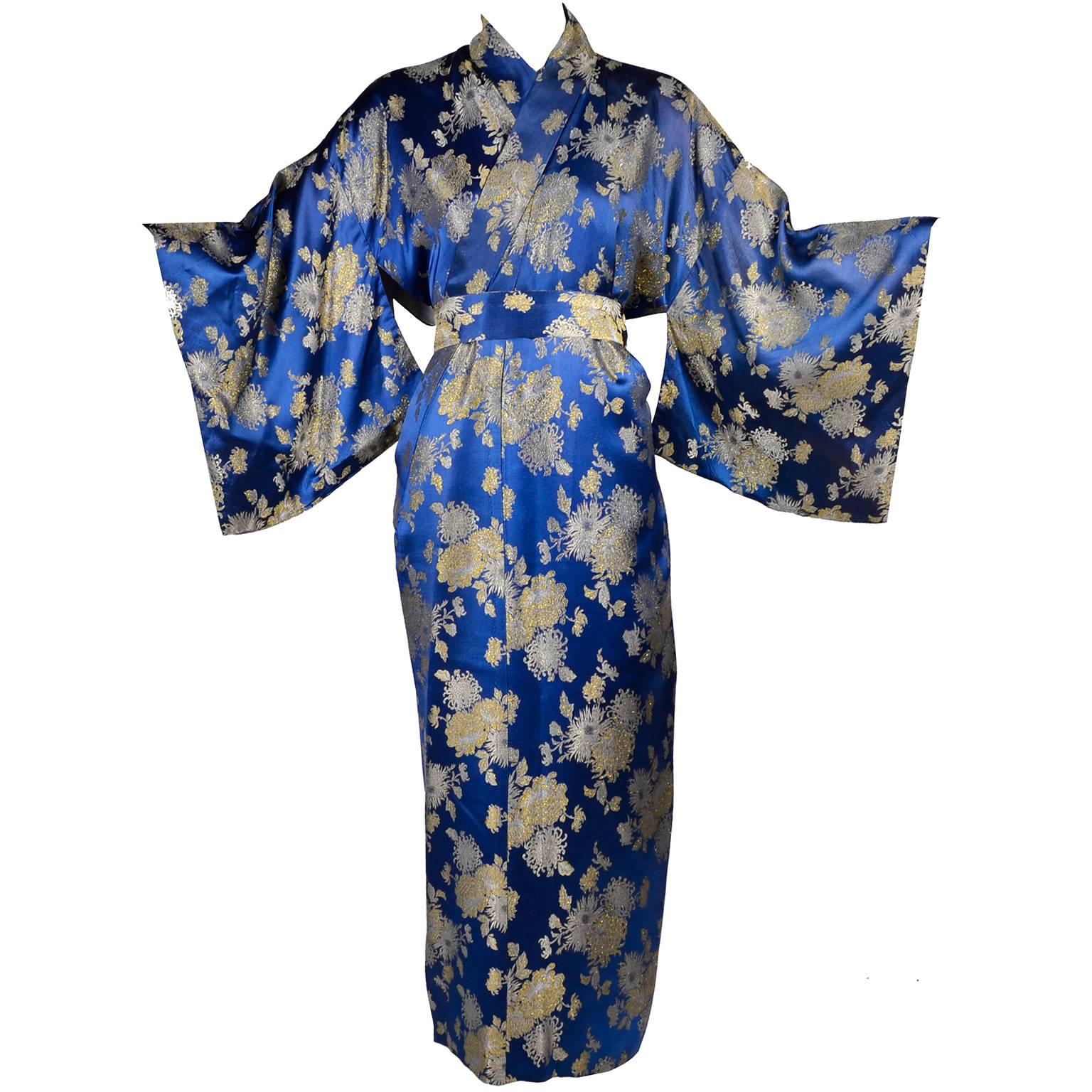 This is a lovely vintage mid century Japanese kimono is a beautiful blue silk fabric with varying shades of gold metallic floral embroidery.  The kimono has a matching fabric sash and is lined in white silk.  There is a label that reads; Best