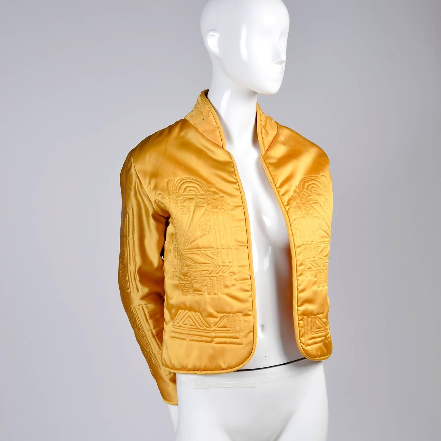 This is a great quilted gold jacket purchased in the late 1980's at a boutique in Portland Oregon called Elizabeth Street. This gorgeous little satin jacket has rolled edges and an open front with art deco style designs quilted into the gold silk.
