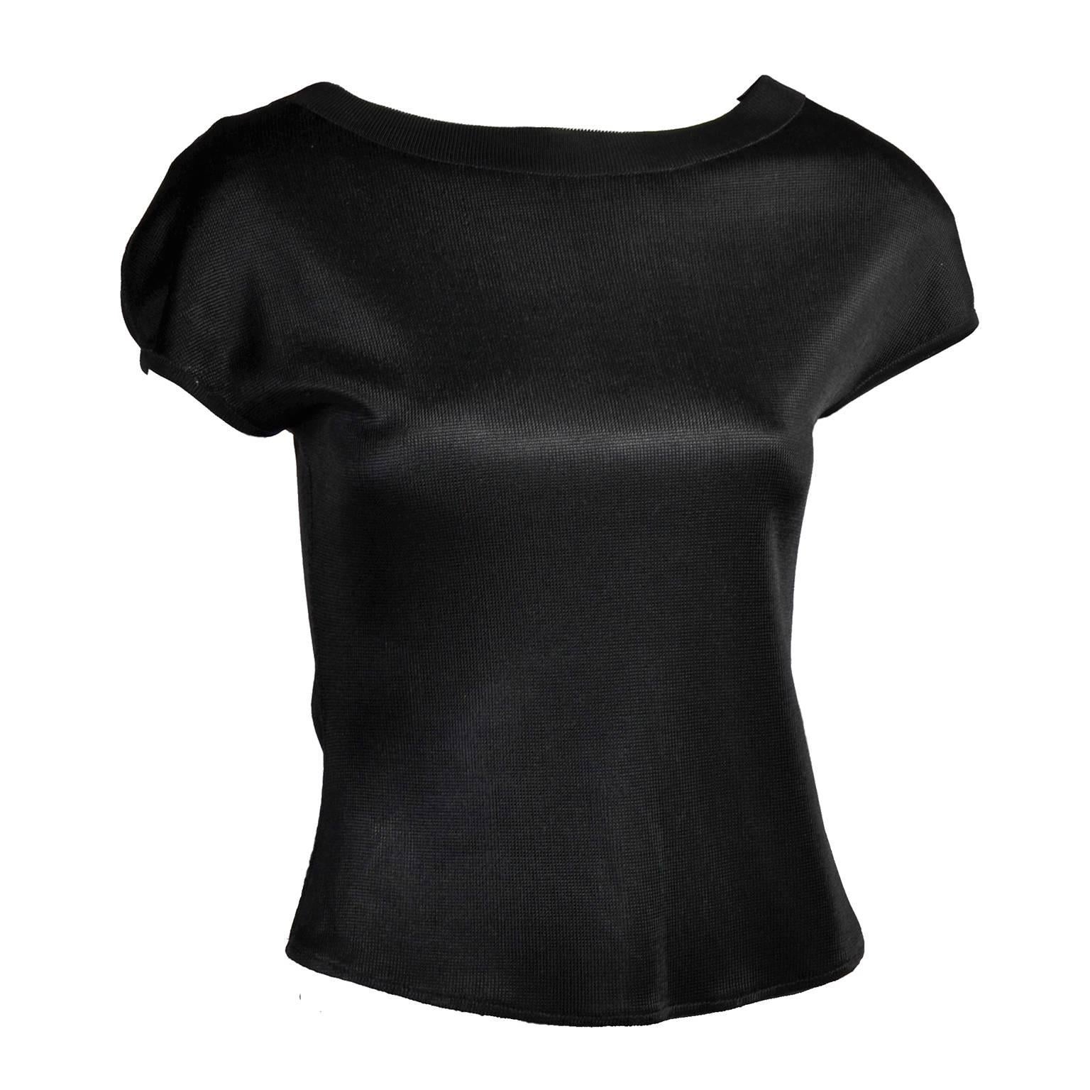 This is a great Alaia vintage top from the late 1980's or early 1990's in black acetate with shoulder pads and back buttons.  Labeled a large, it fits a size M/L depending on how loose you like to wear your tops. 